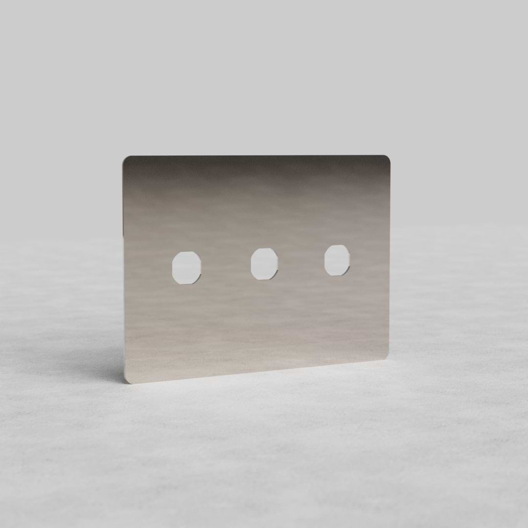 3G Switch Plate Kew US in polished nickel with three switch openings, shown on a light textured surface.