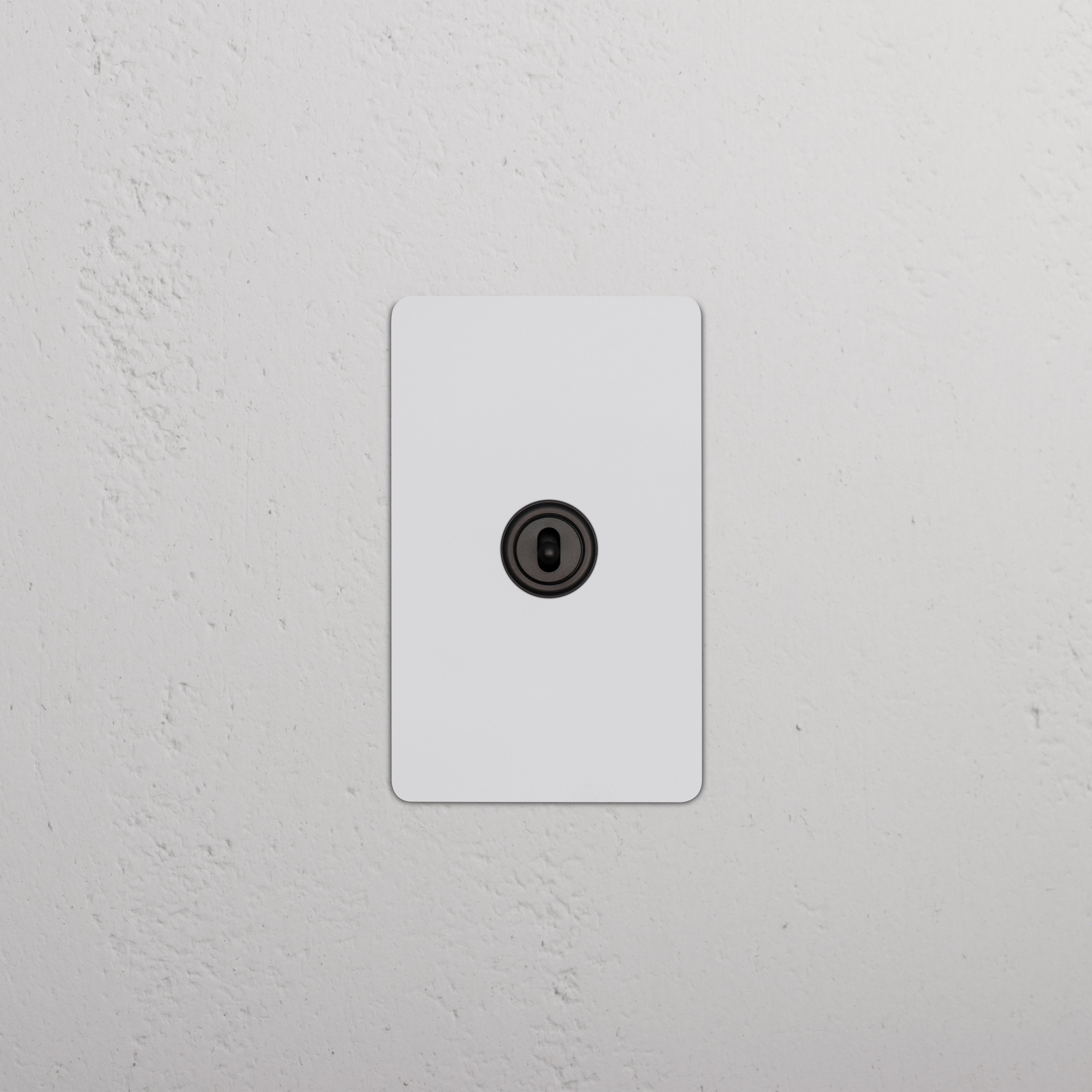 Kew 1G Center Retractive Toggle Switch in paintable bronze finish, single gang wall-mounted switch.