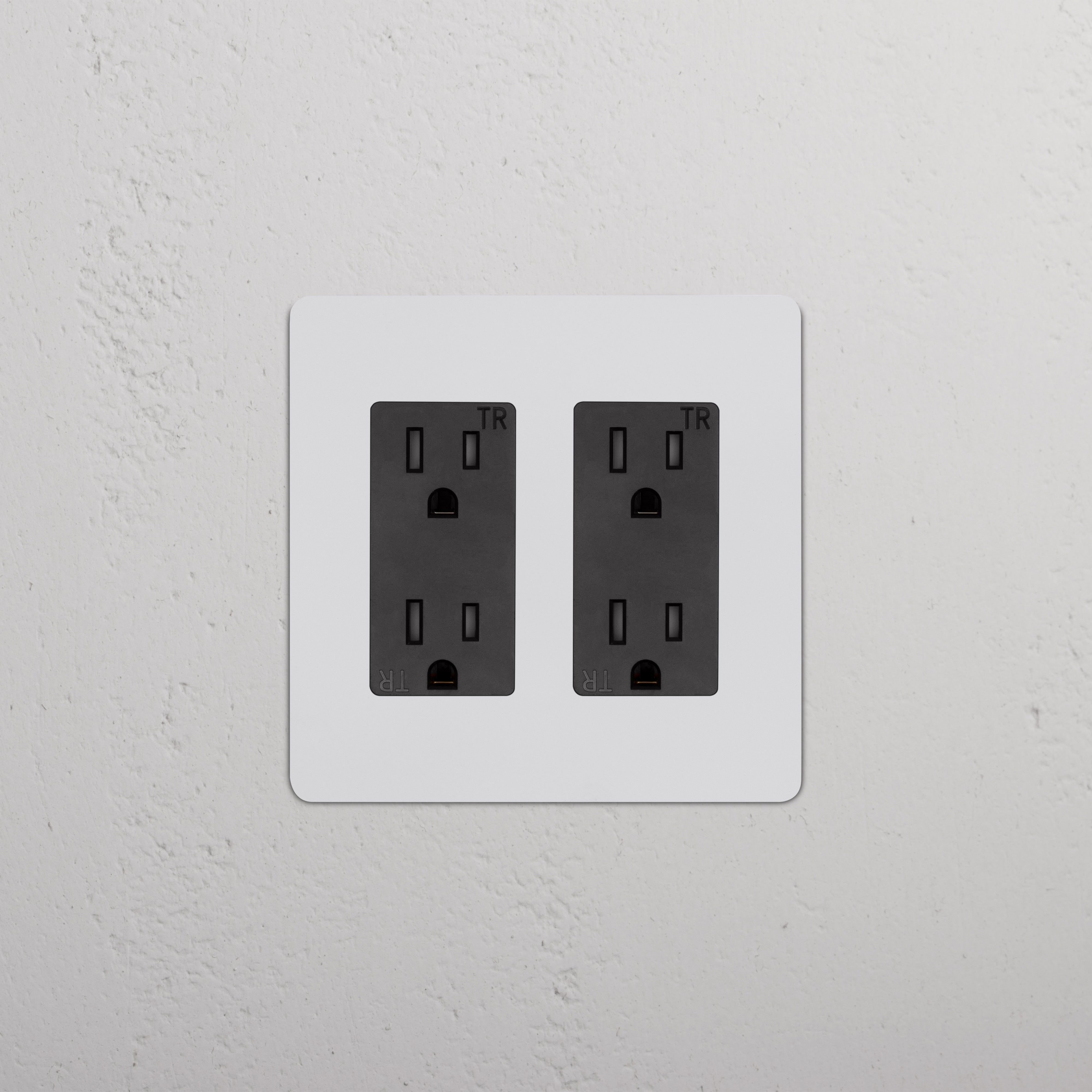 Kew 2G Outlet - Paintable Black: double power socket with paintable black finish on a wall.