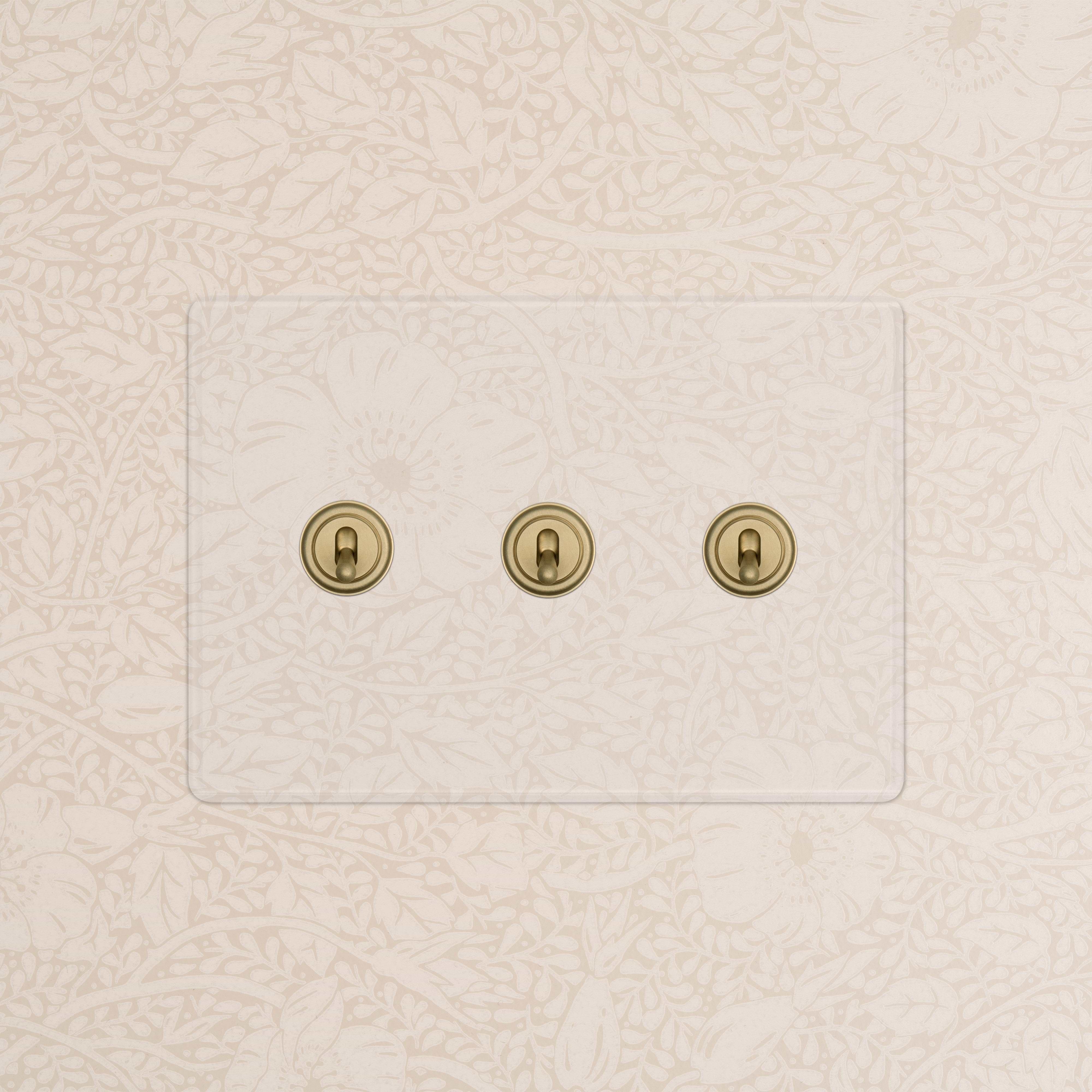 Kew 3G Toggle Switch in clear antique brass with three toggles, designed for wall mounting.