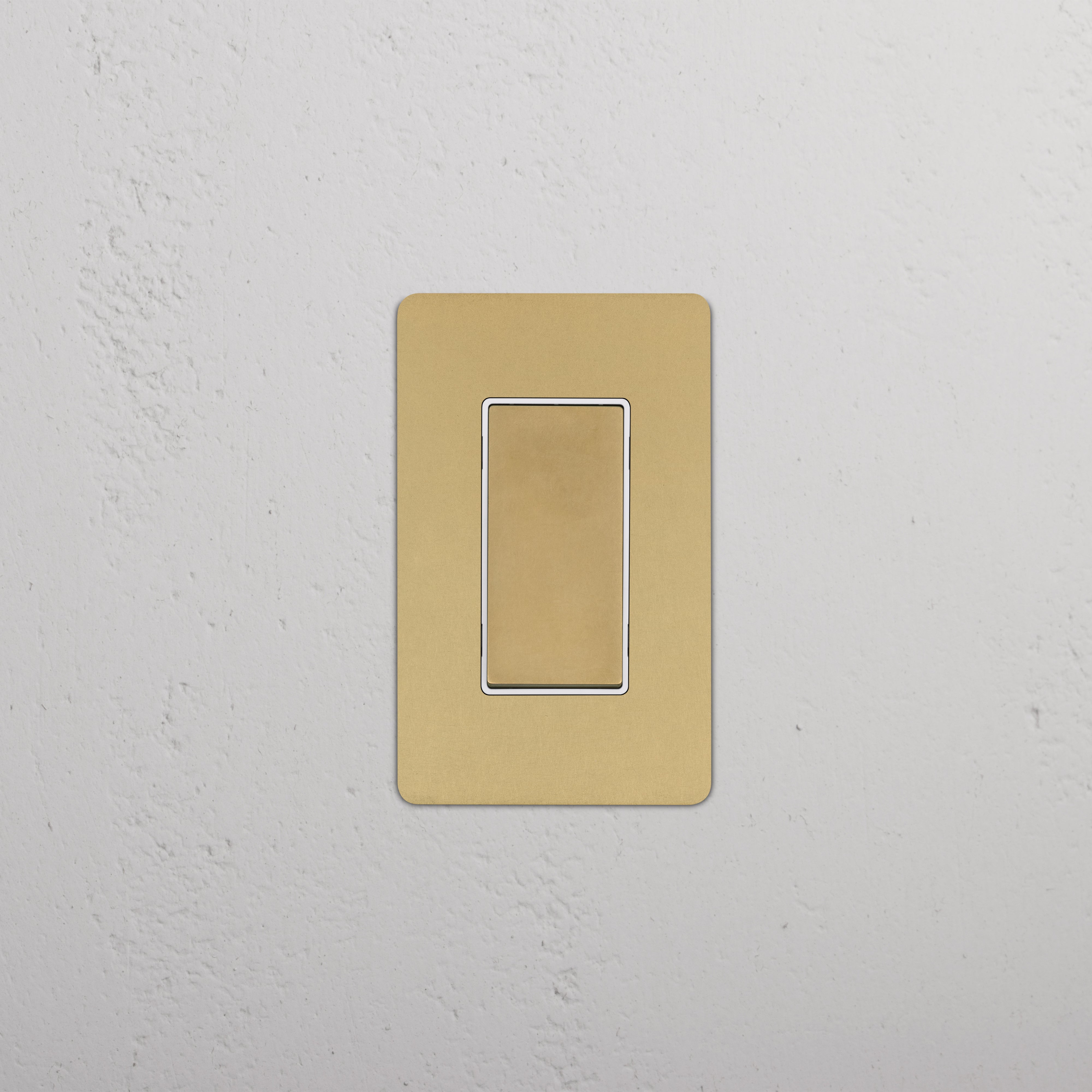 Kew 1G Dimming Retractive Rocker Switch in antique brass and white, mounted on a white textured wall.