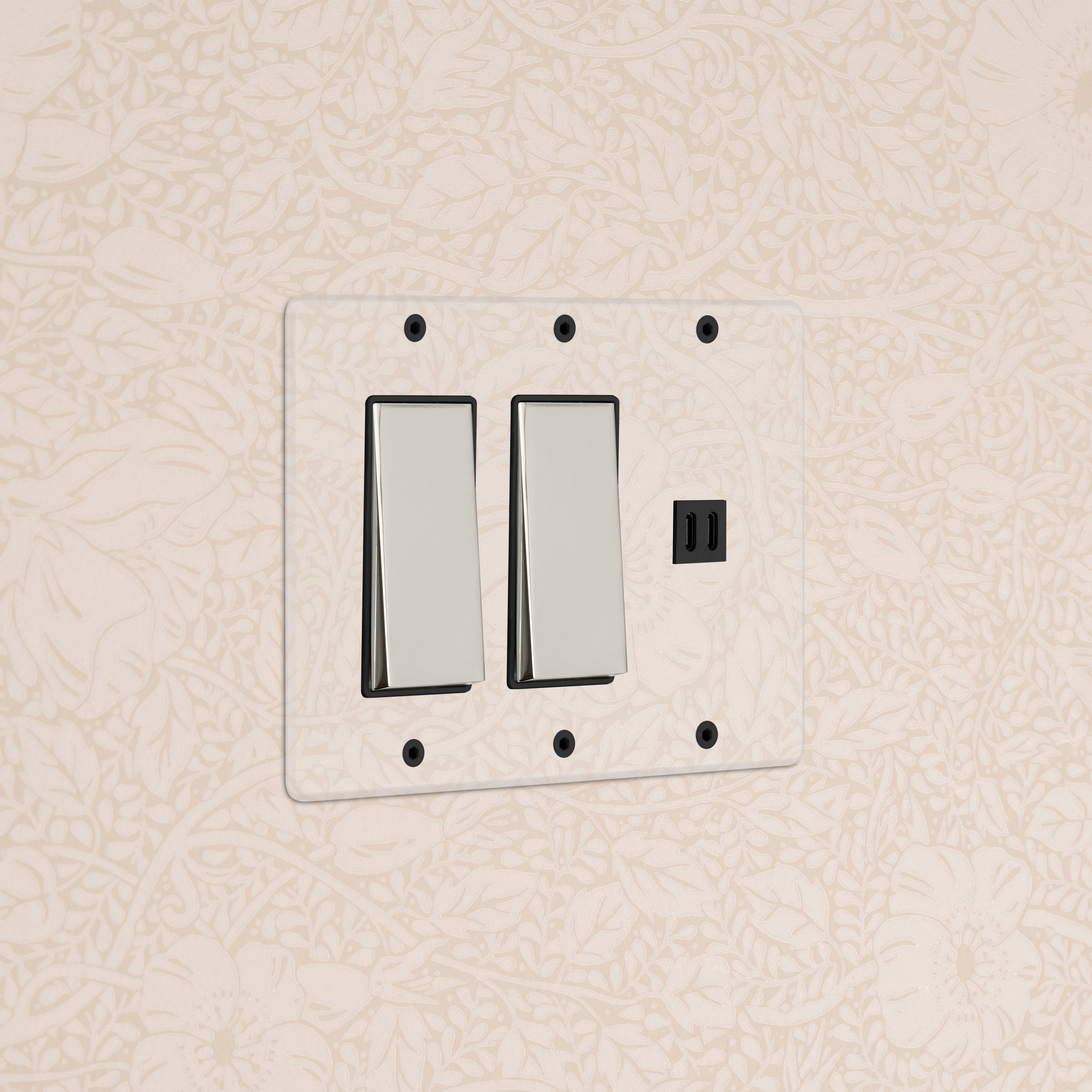 Kew 3G 2x Rocker Switch & Fast Charge USB in clear polished nickel black on a beige floral patterned wall.