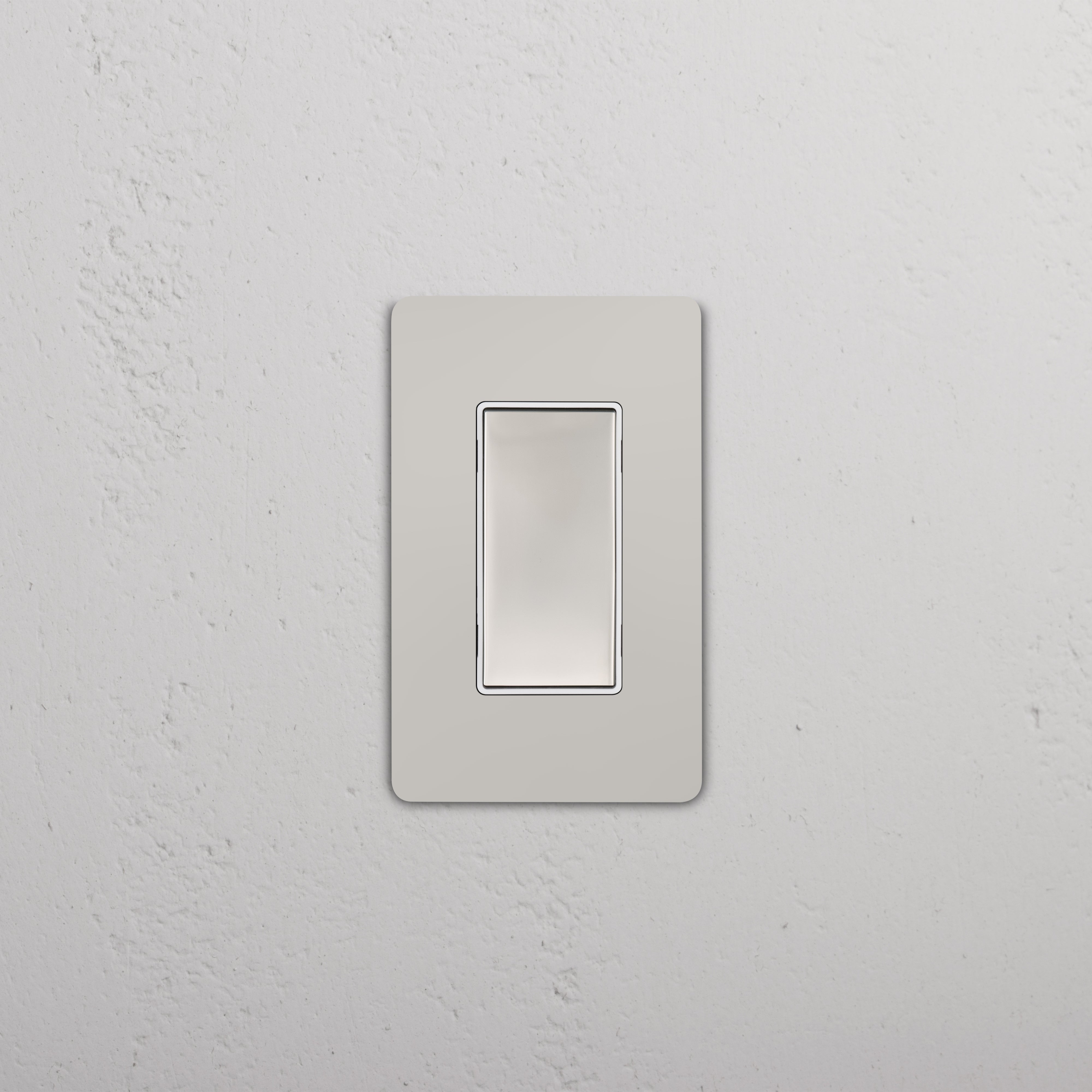 Grove 1G Center Retractive Rocker Switch in polished nickel white, shown mounted on a white wall.