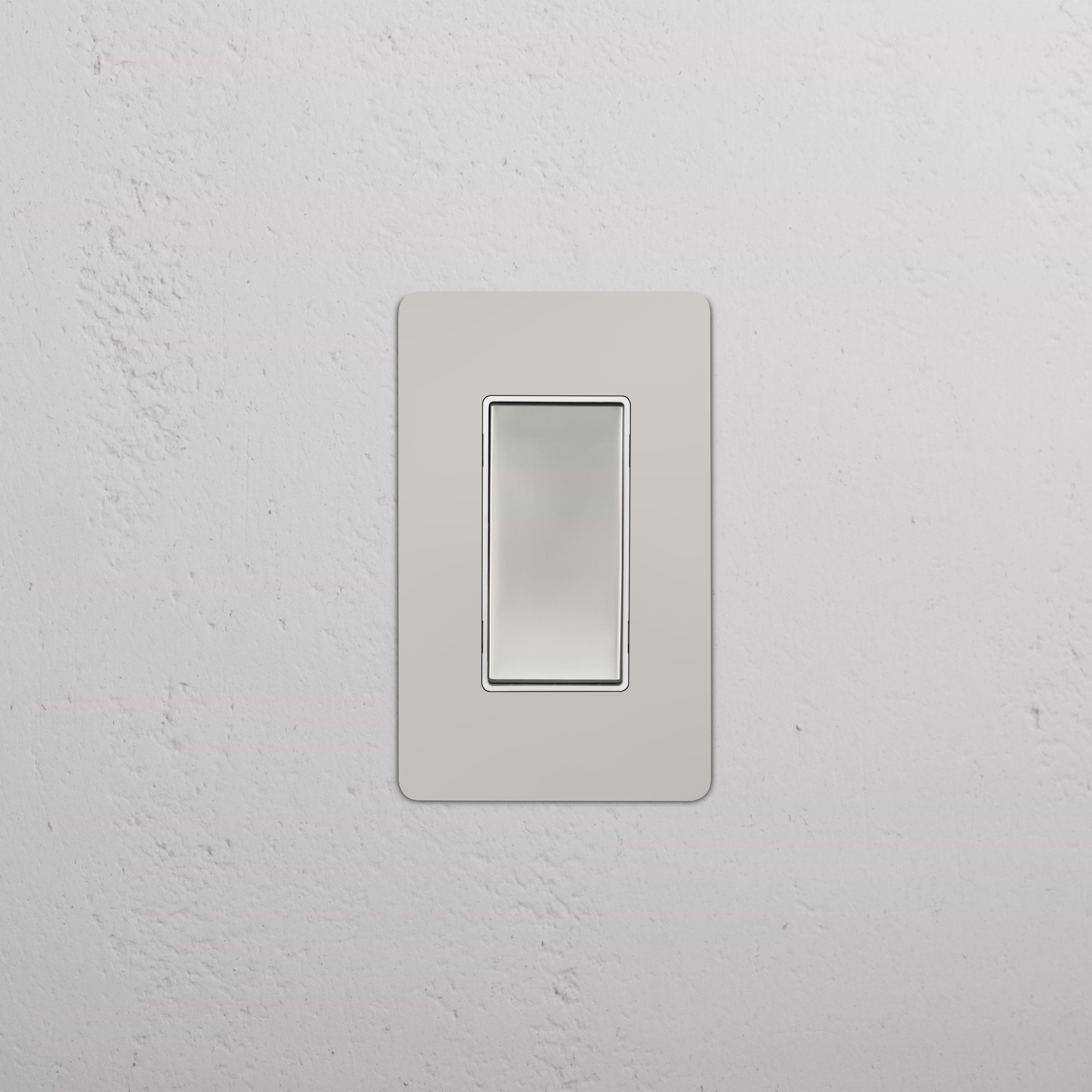 Kew 1G Dimming Retractive Rocker Switch in polished nickel white, shown installed on a white wall.