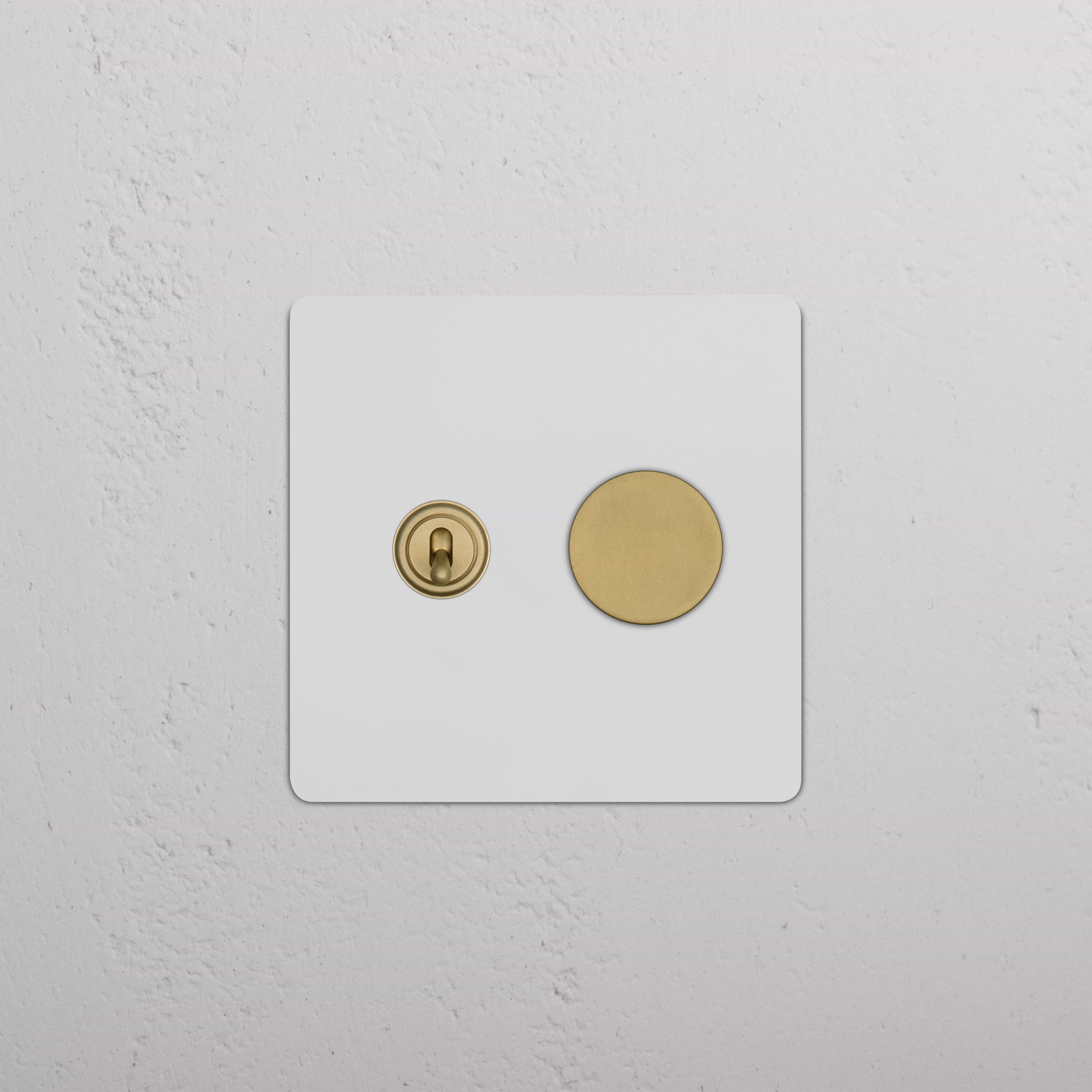 Kew 2G Toggle & Dimmer Switch with paintable antique brass finish, shown mounted on a white wall.