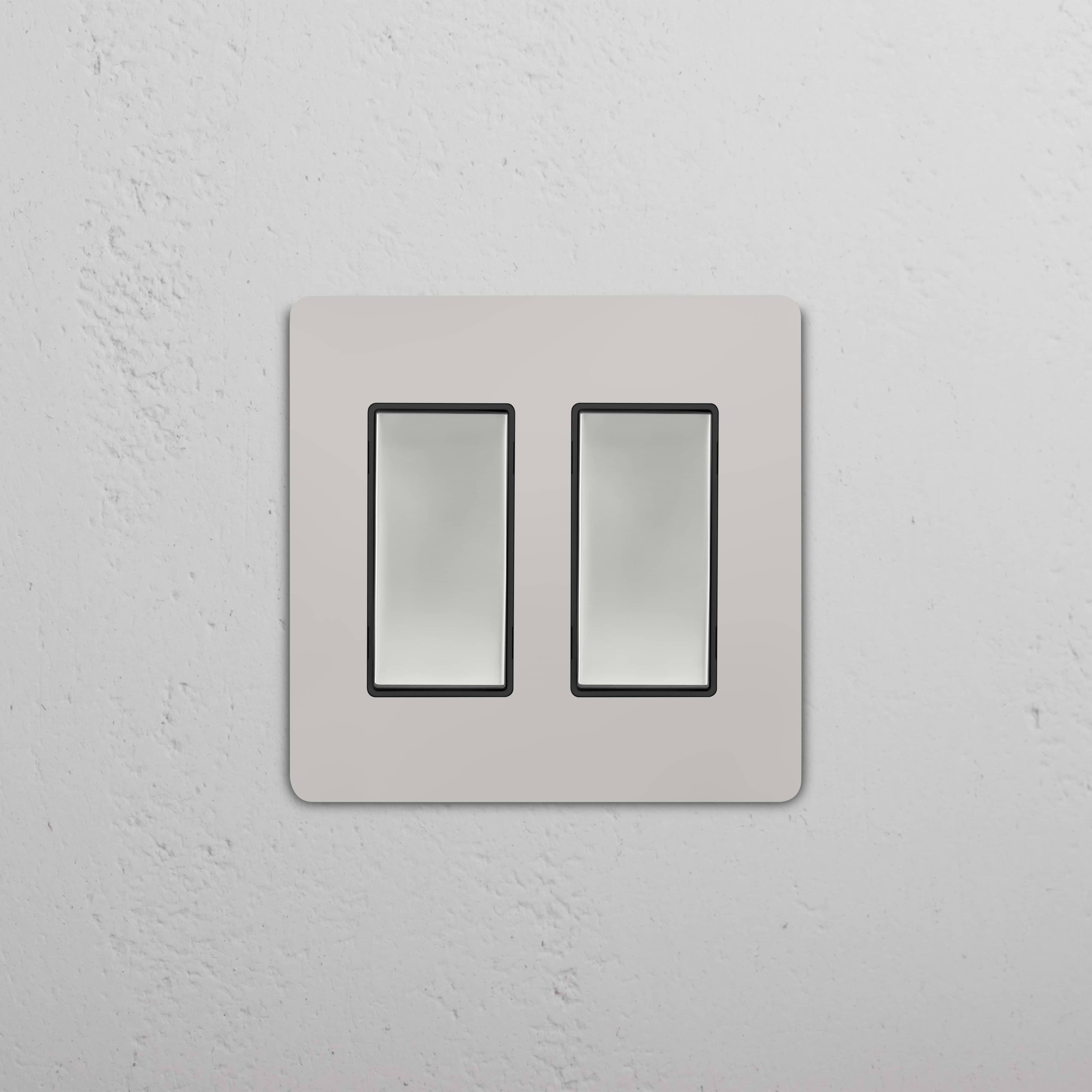 Grove 2G Rocker Switch in polished nickel black, double rectangular switches on a textured white wall.