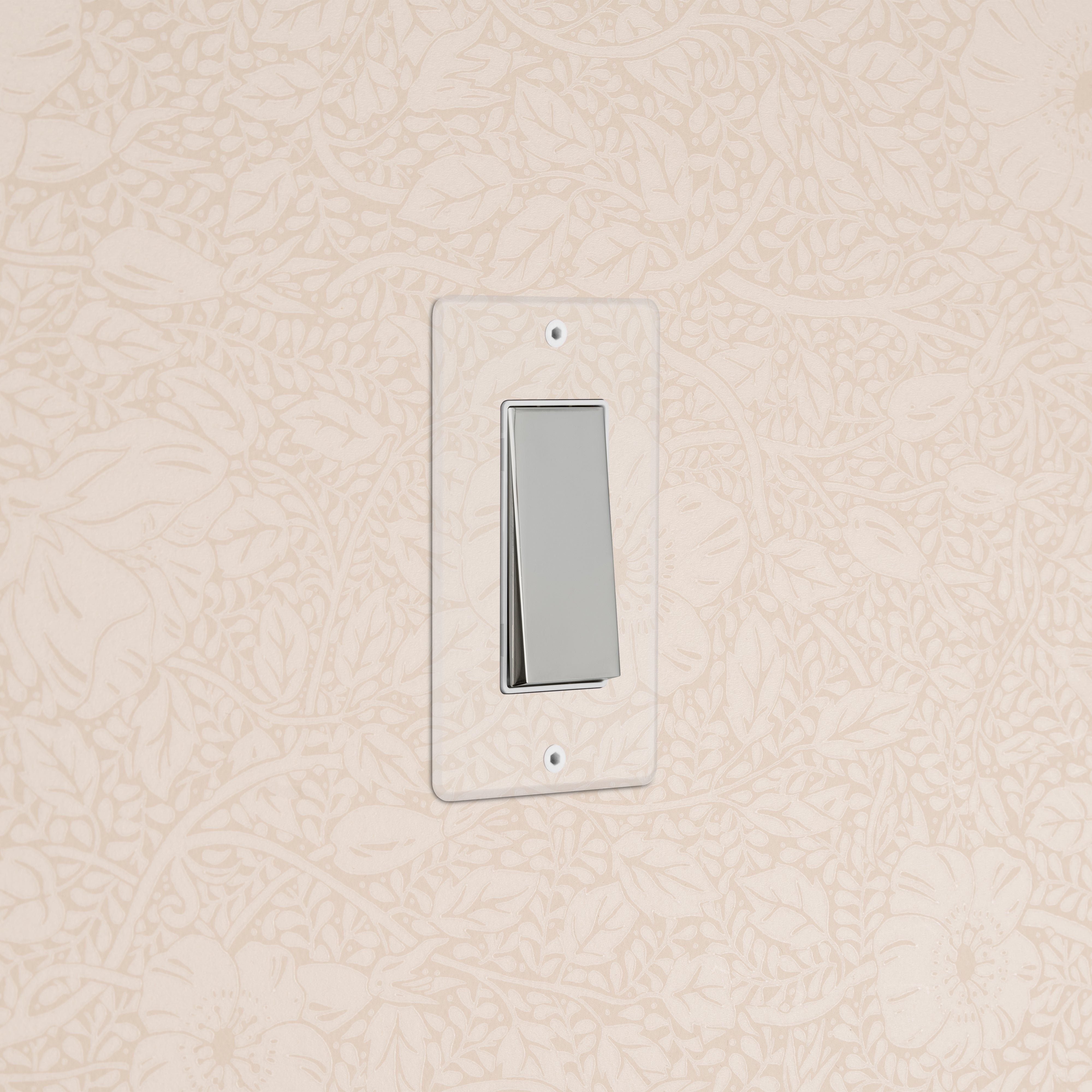 Kew 1G Rocker Switch in clear polished nickel with white insert, mounted on floral-patterned wallpaper.