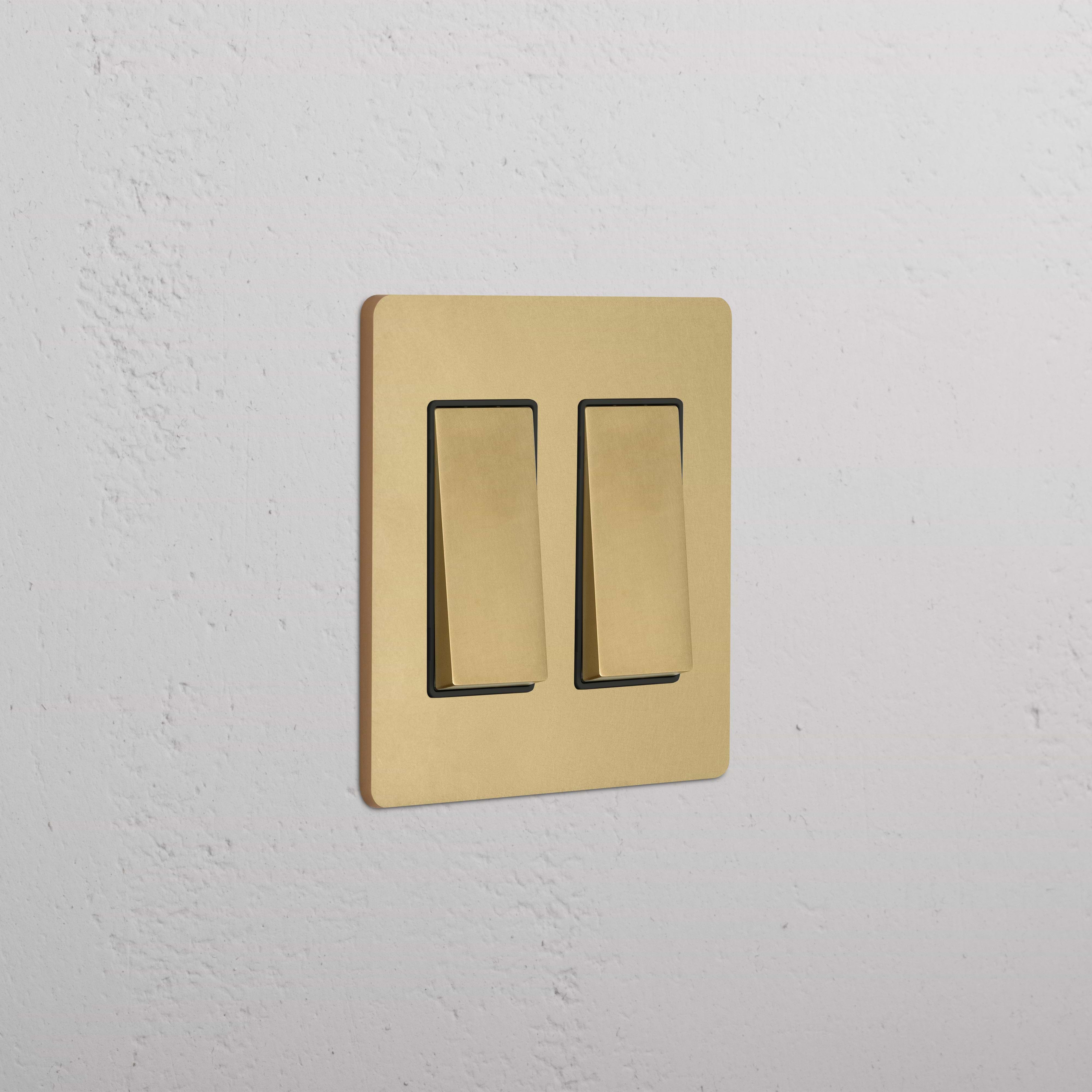 Grove 2G Rocker Switch in Antique Brass Black finish, featuring two rectangular switches on a wall.