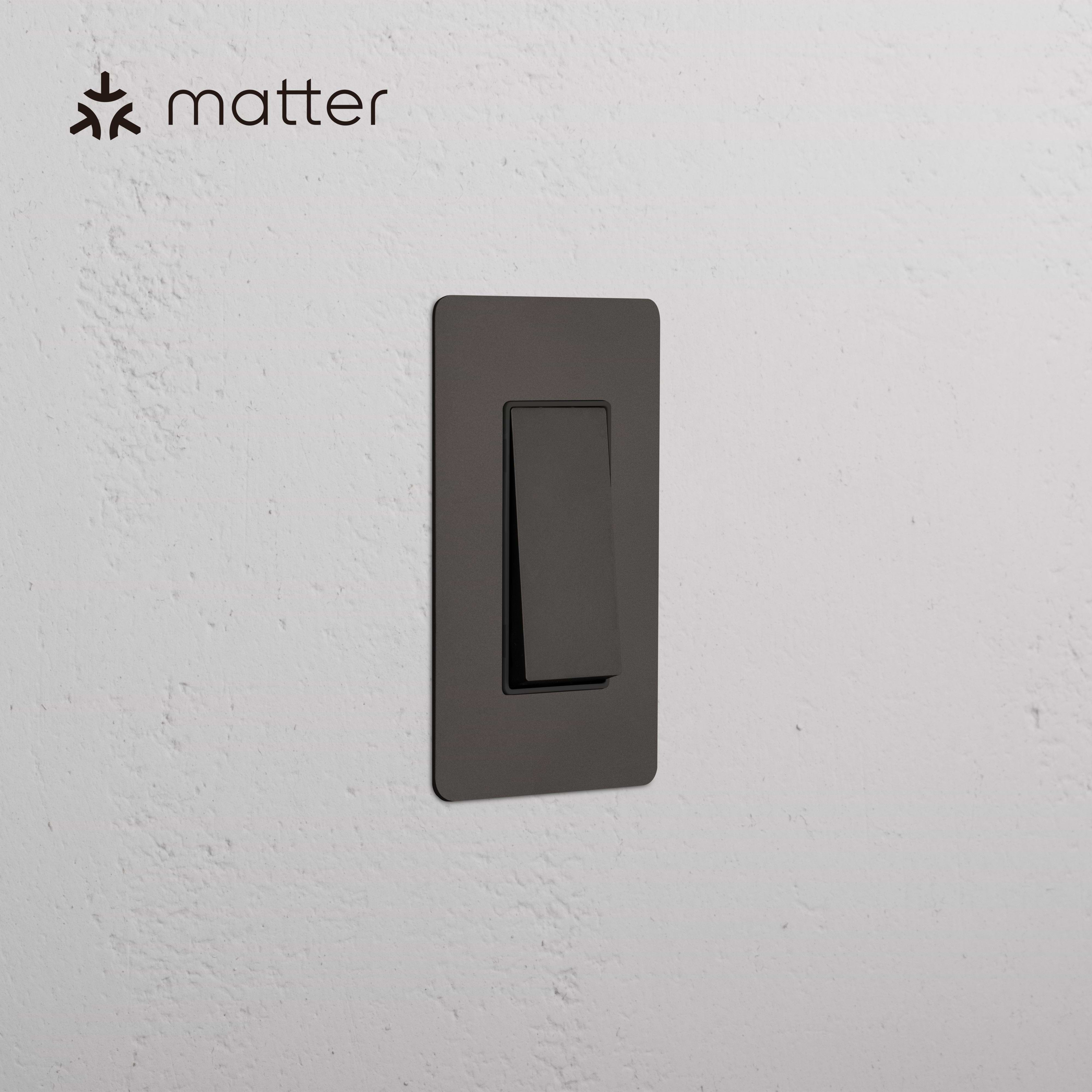 Kew 1G Smart Retractive Rocker Switch in Bronze Black, wall-mounted, with 'matter' logo in top left corner.