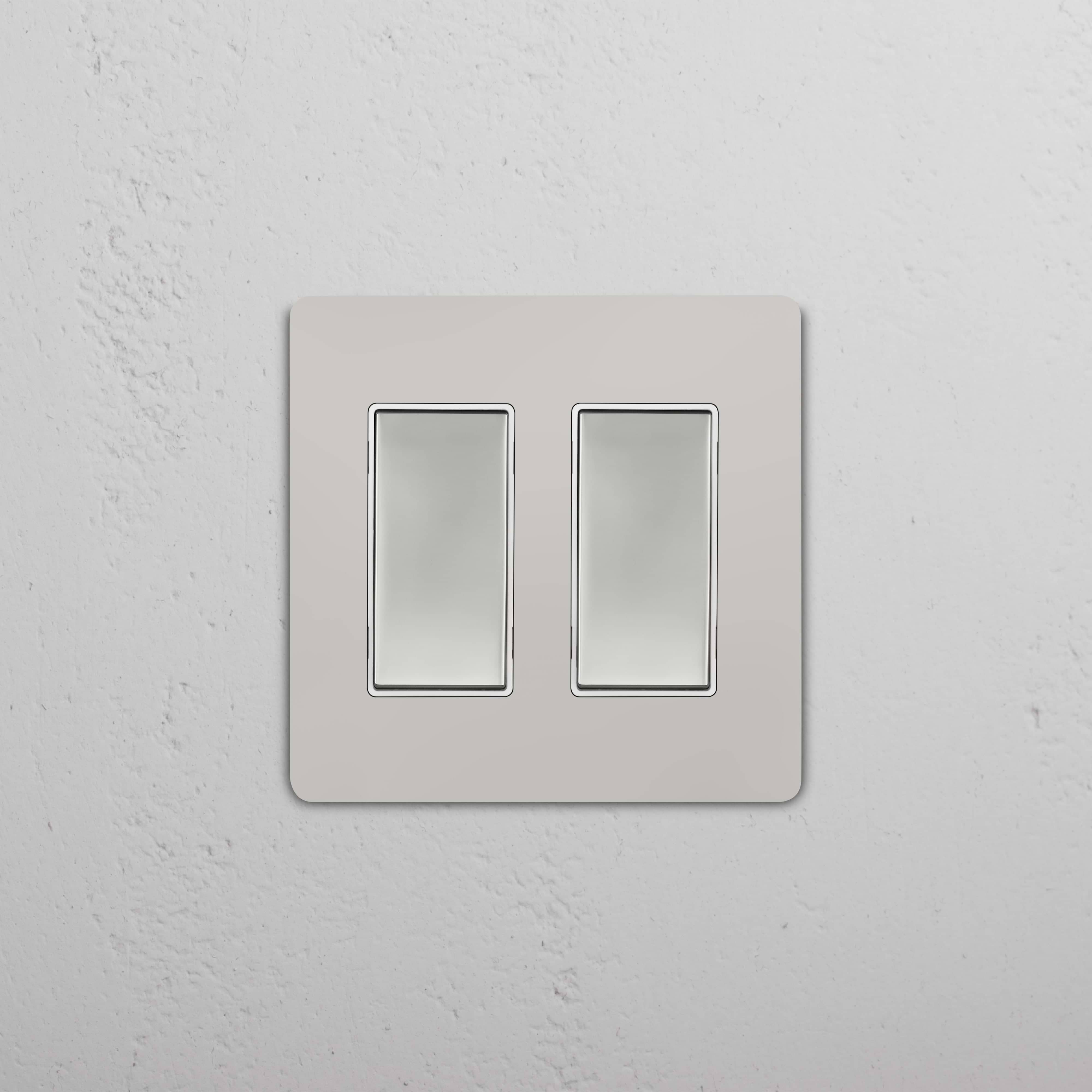Grove 2G Rocker Switch in Polished Nickel White, both switches off, mounted on a white wall.
