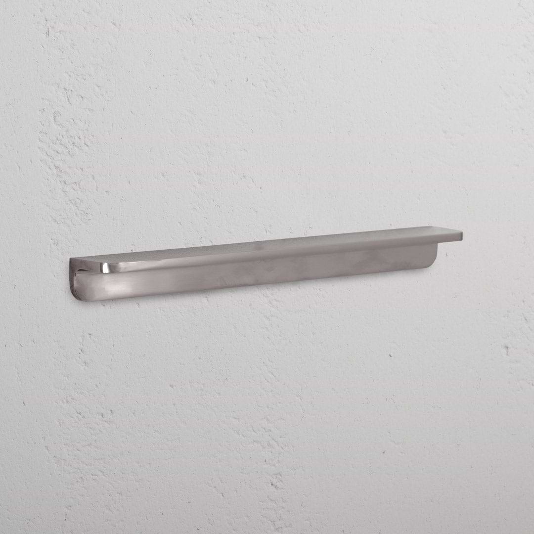 Medium-sized Oxford Furniture Handle in polished nickel finish, for cabinets or drawers, mounted on white surface.