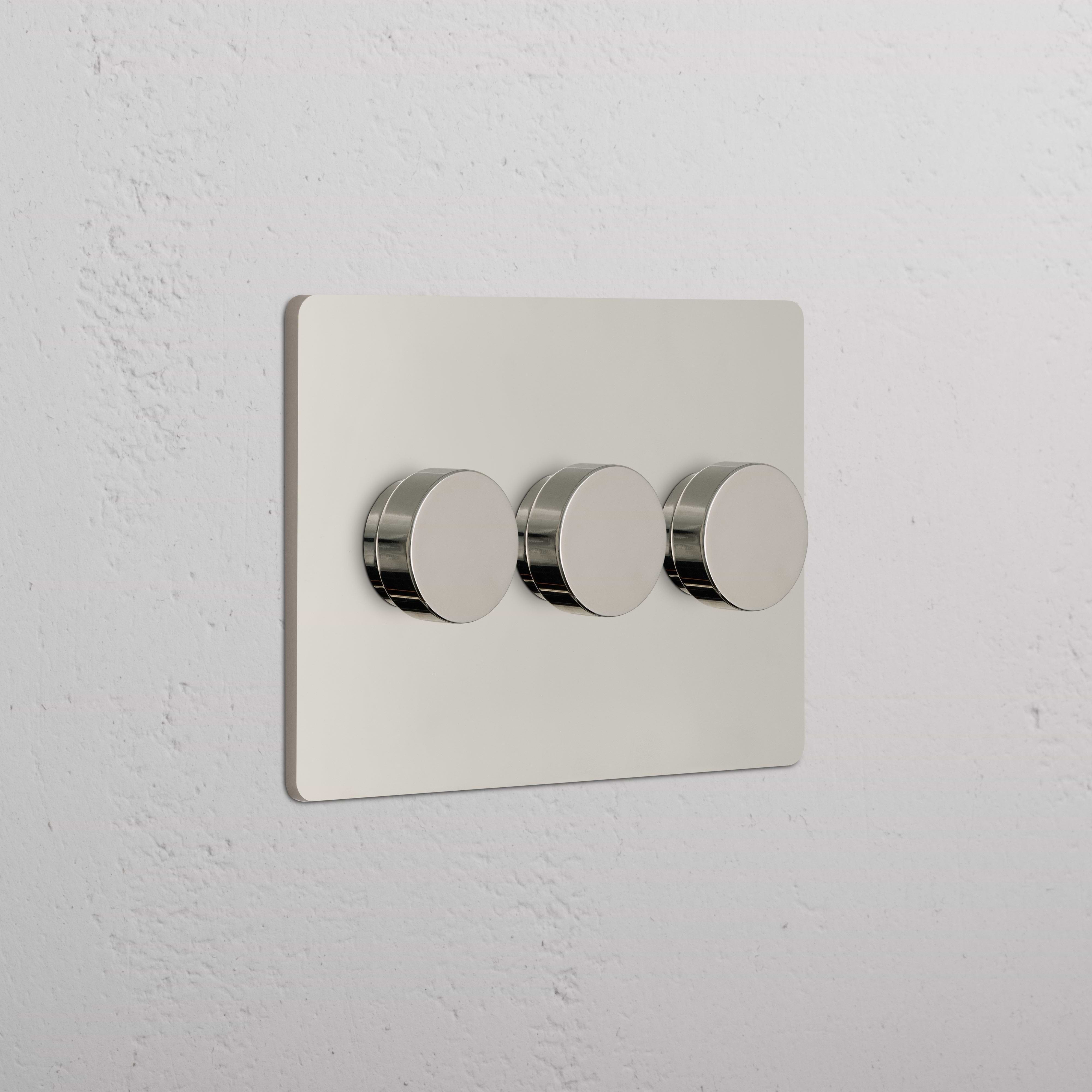 Grove 3G Dimmer Switch in polished nickel with three round control knobs on a white wall.