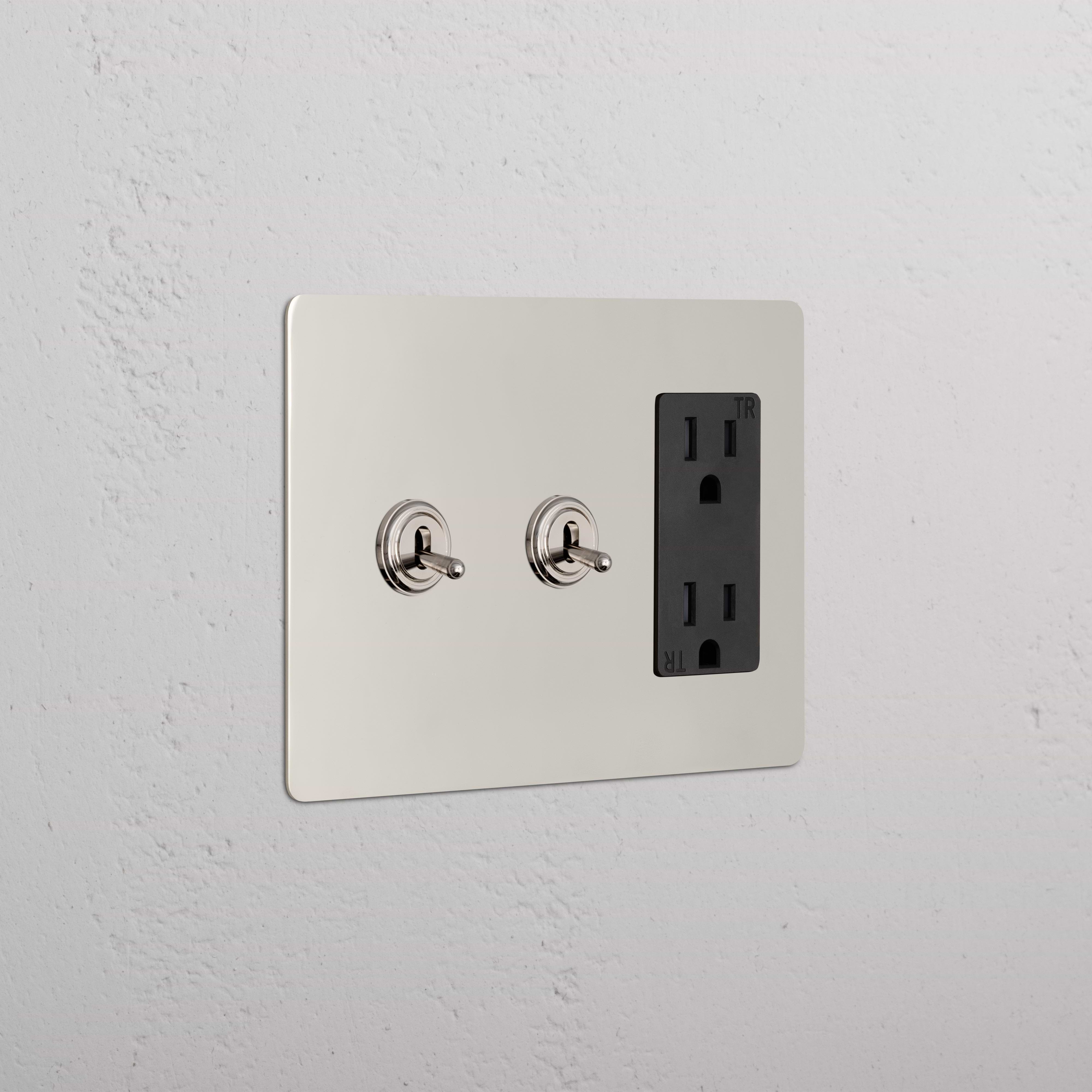 Kew 3G 2x Toggle Switch & Outlet in Polished Nickel Black with two toggles and a double outlet on a wall.