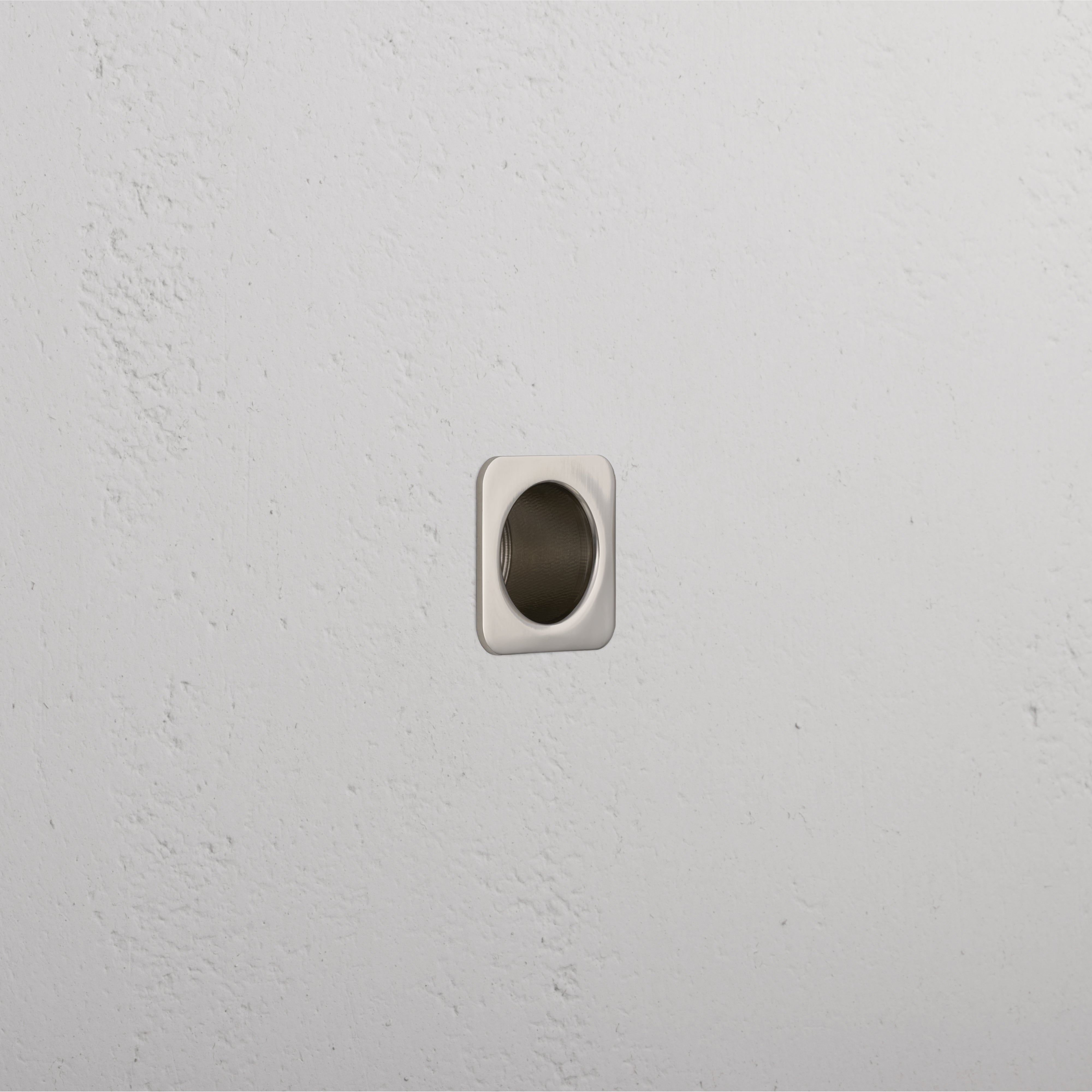 Close-up of a Regent Recessed Edge Pull in polished nickel, installed on a flat surface for cabinet or drawer use.