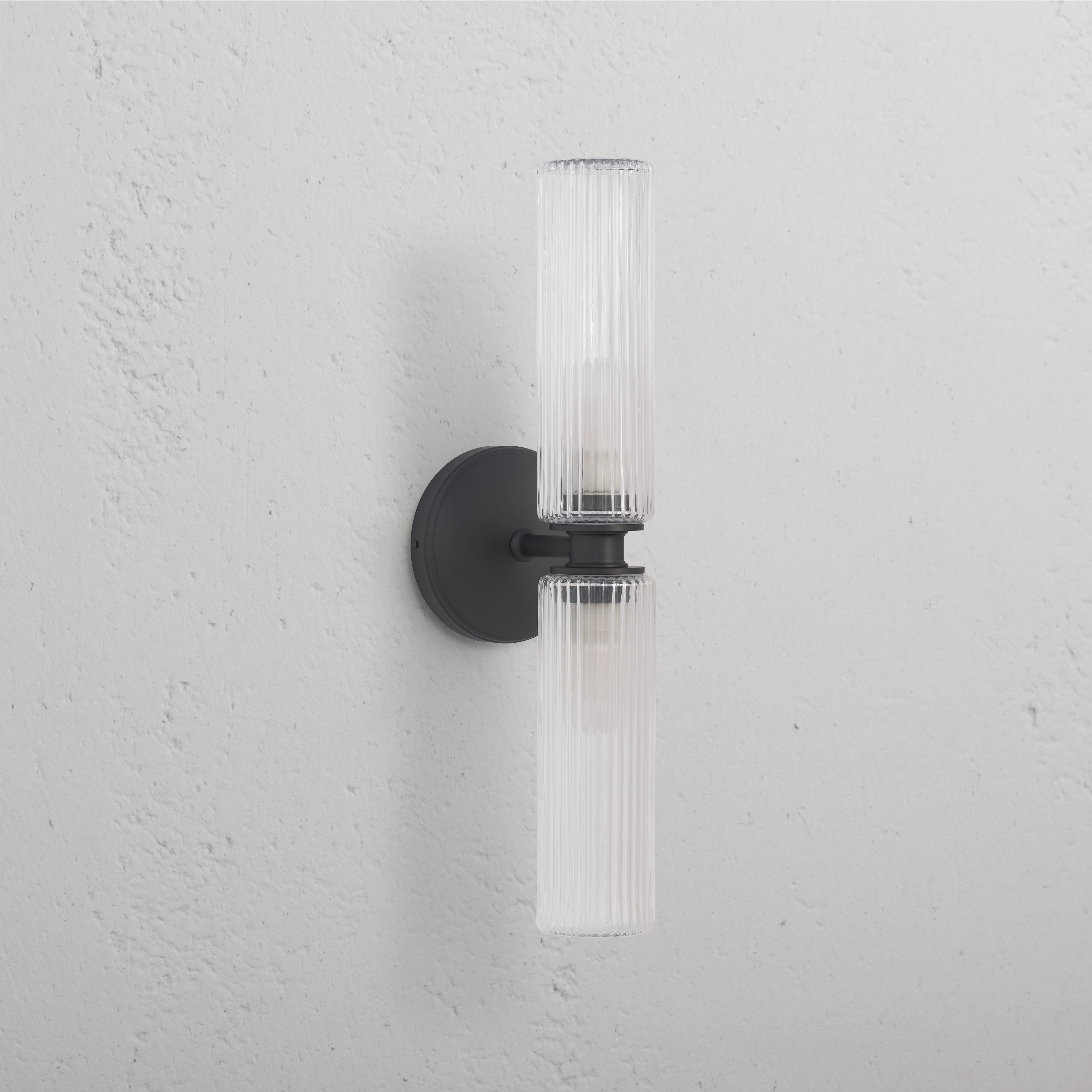 Claremont Medium Wall Light with fluted glass shades and bronze finish, mounted on a white wall.