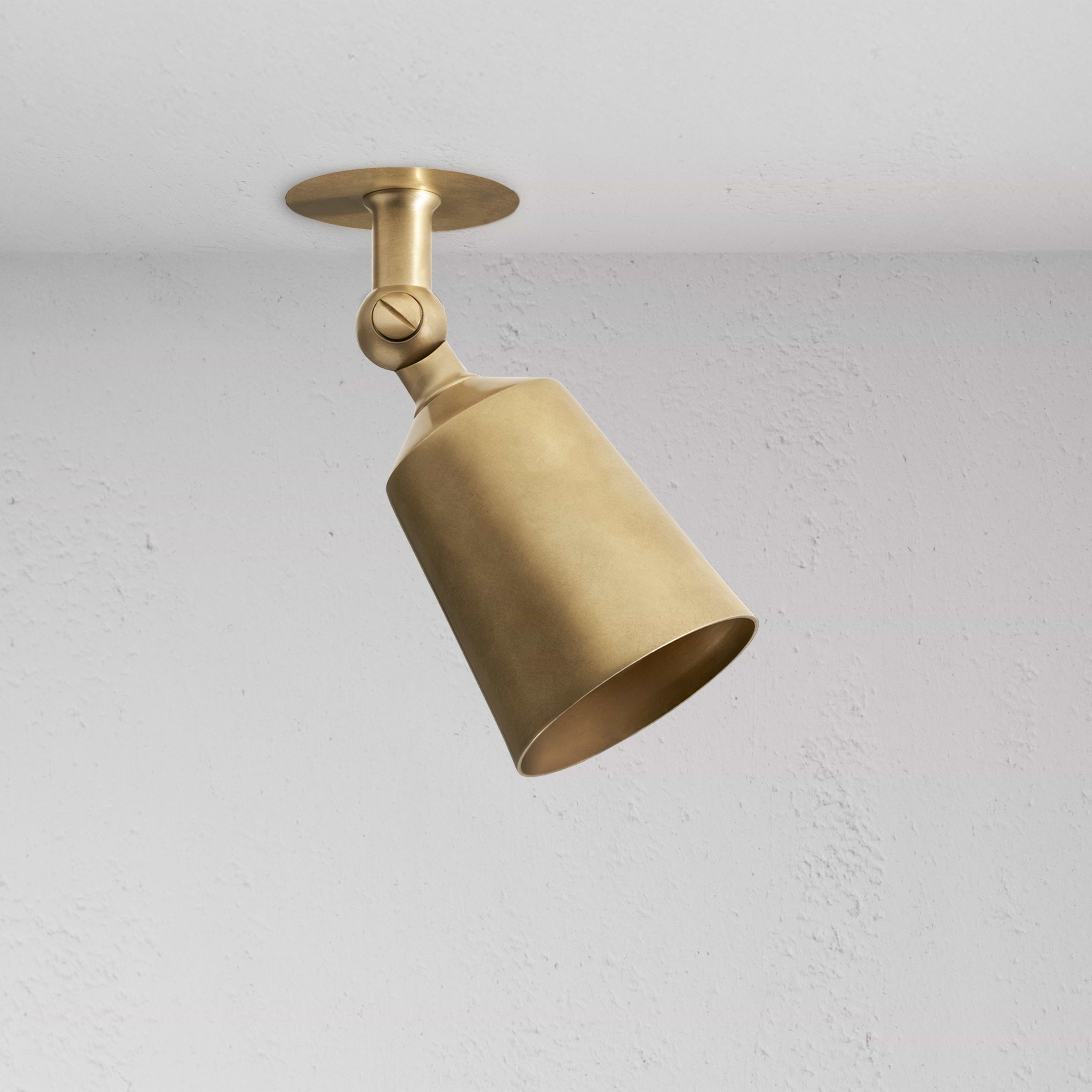 Perryn Single 50mm Spotlight in antique brass with a cone-shaped shade, angled downward on a ceiling mount.