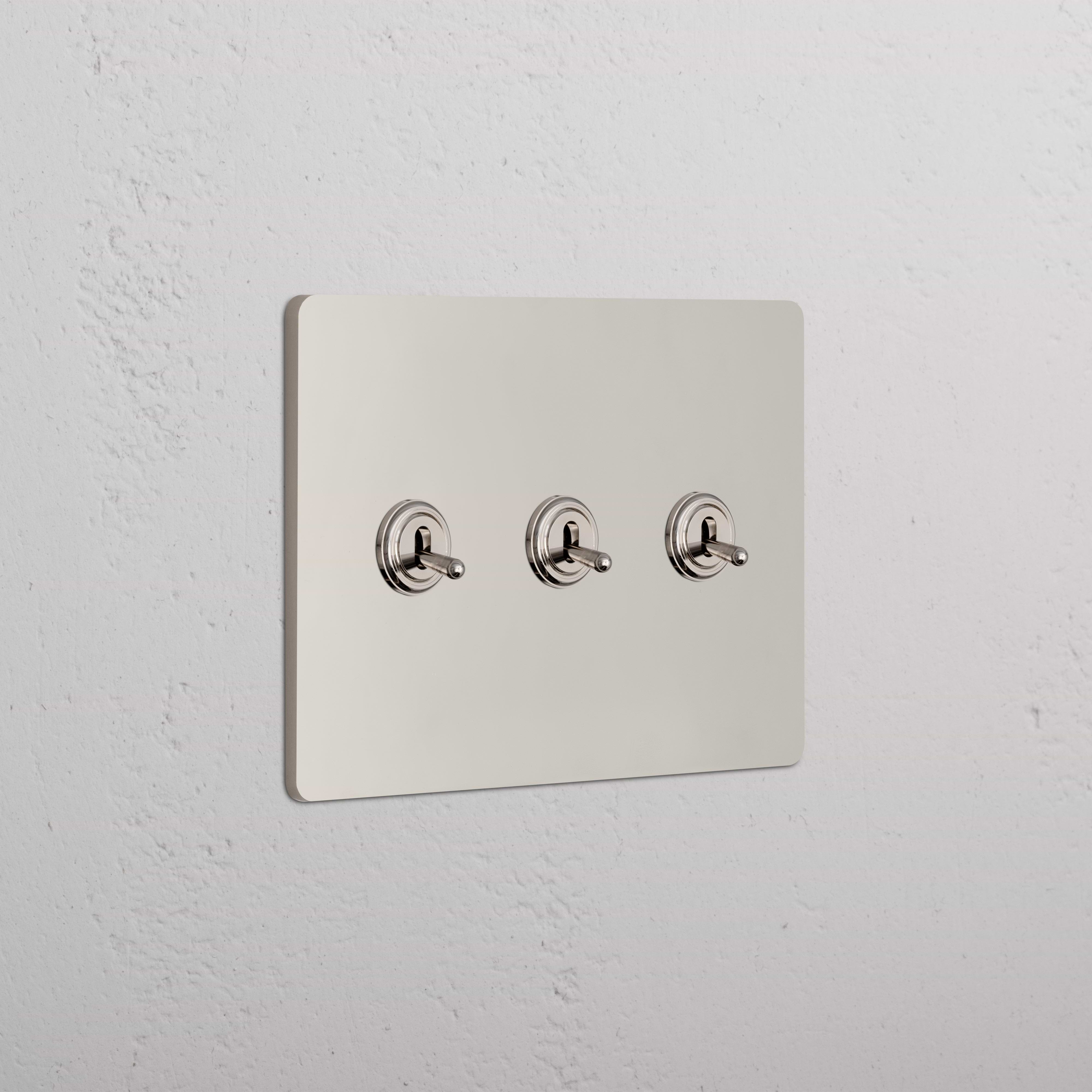 Grove 3G Toggle Switch in polished nickel with three horizontal switches on a metallic wall plate.