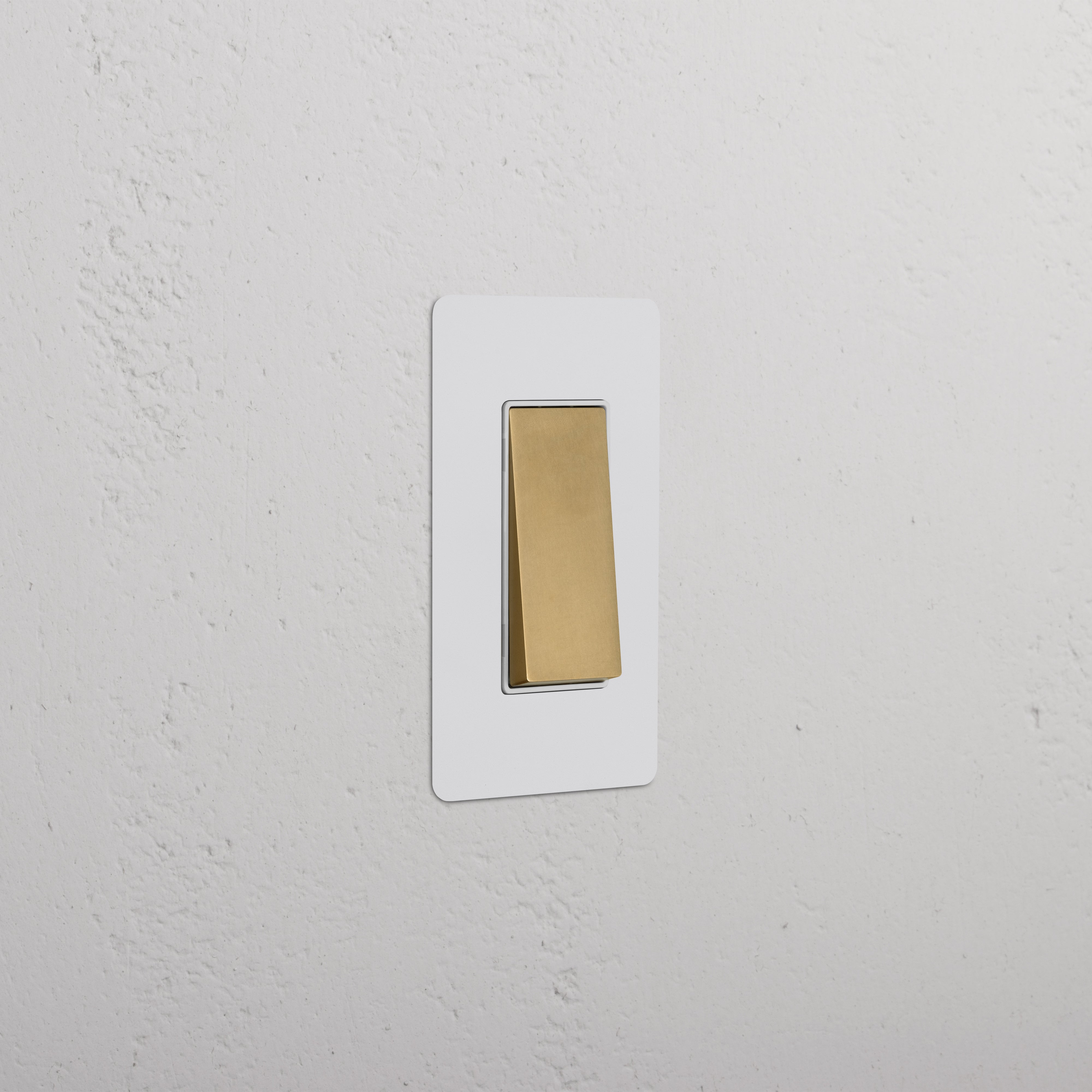 Kew 1G Rocker Switch in paintable antique brass white with gold toggle and white rectangular plate.