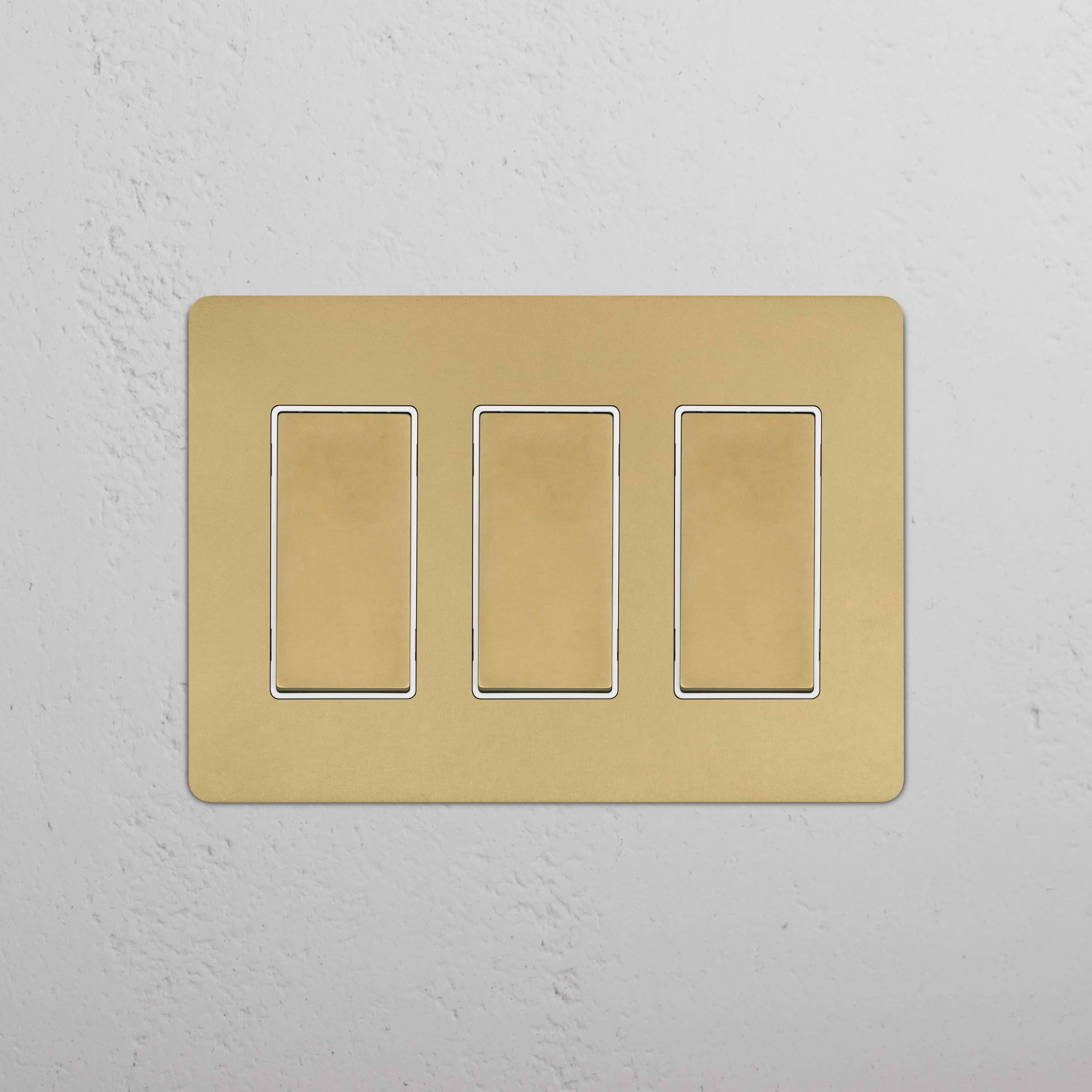 Kew 3G Rocker Switch in antique brass white finish with three rectangular gold-colored rocker switches.