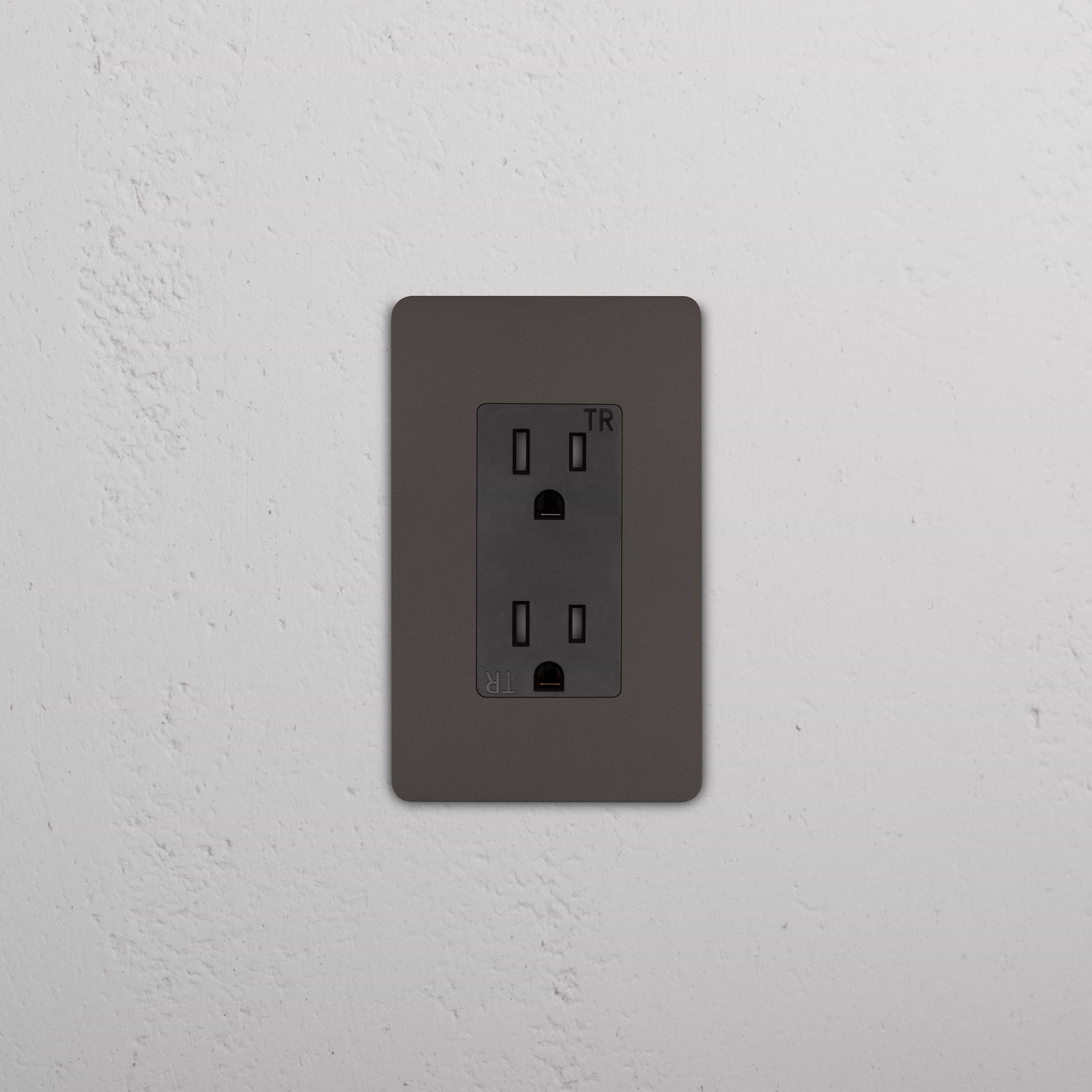 Grove 1G 15A Outlet in Bronze Black finish with two sockets, installed on a white textured wall.