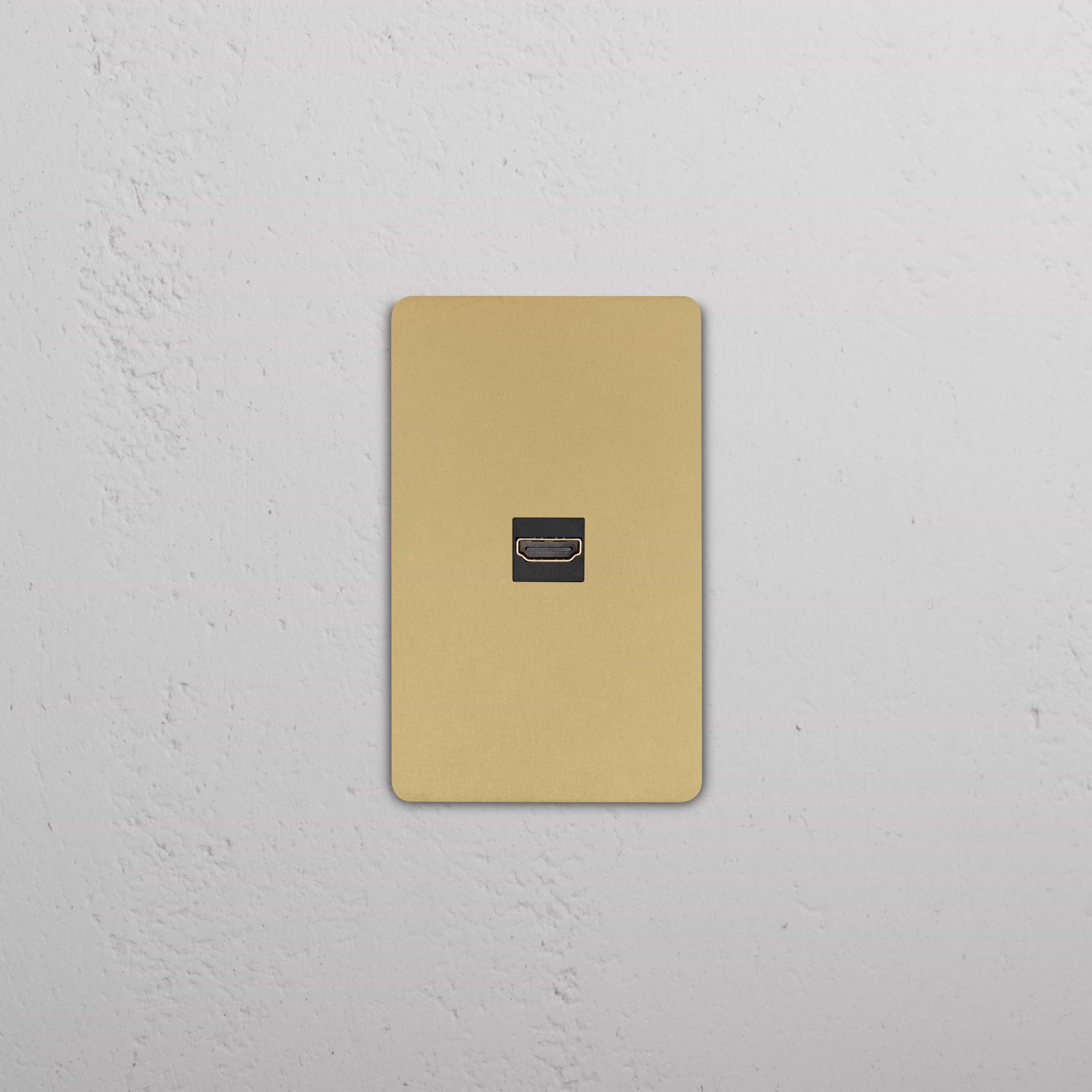 Grove 1G HDMI keystone wall plate in Antique Brass Black finish, installed on a white textured wall.