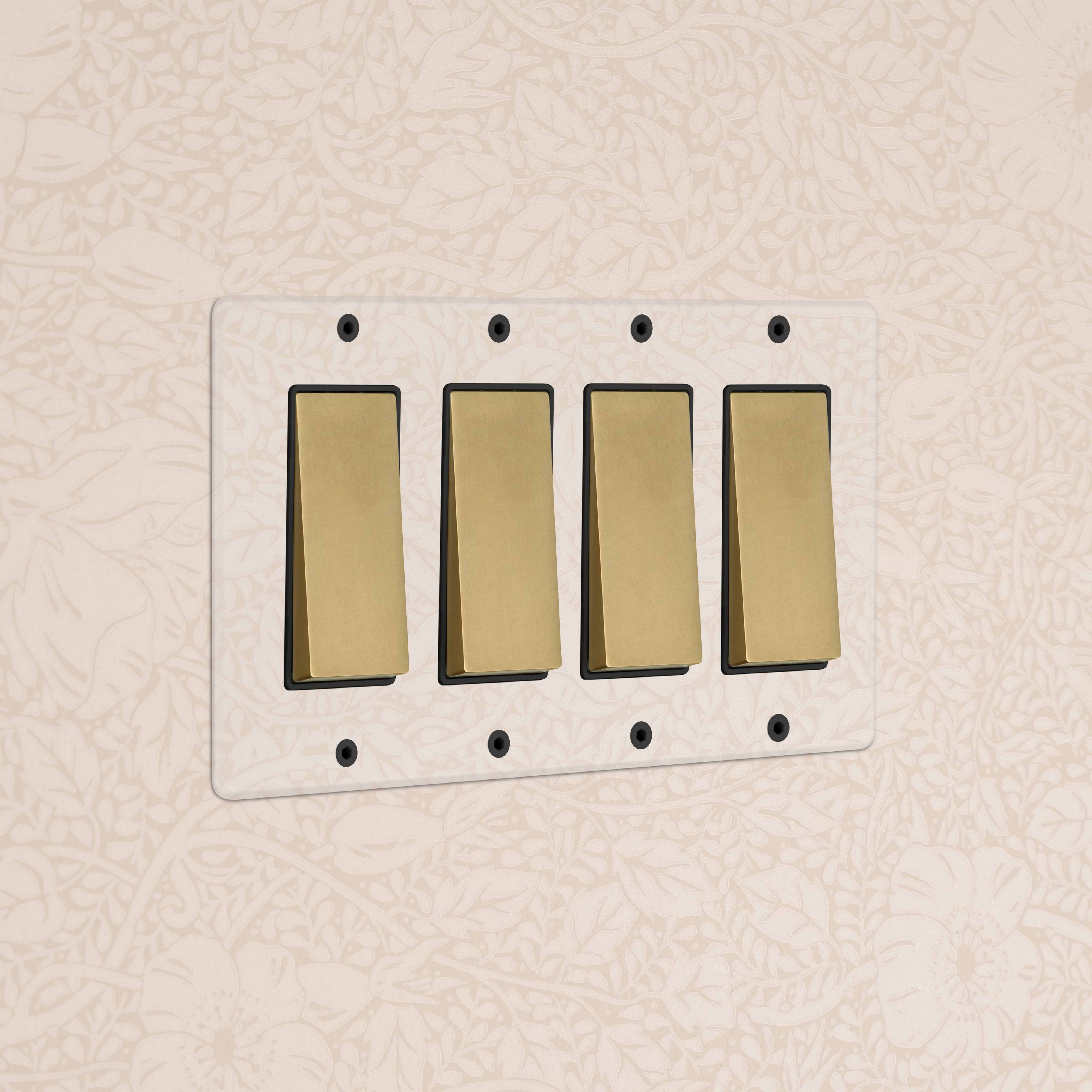 Kew 4G Rocker Switch in clear antique brass black finish, mounted on a wall with floral wallpaper.