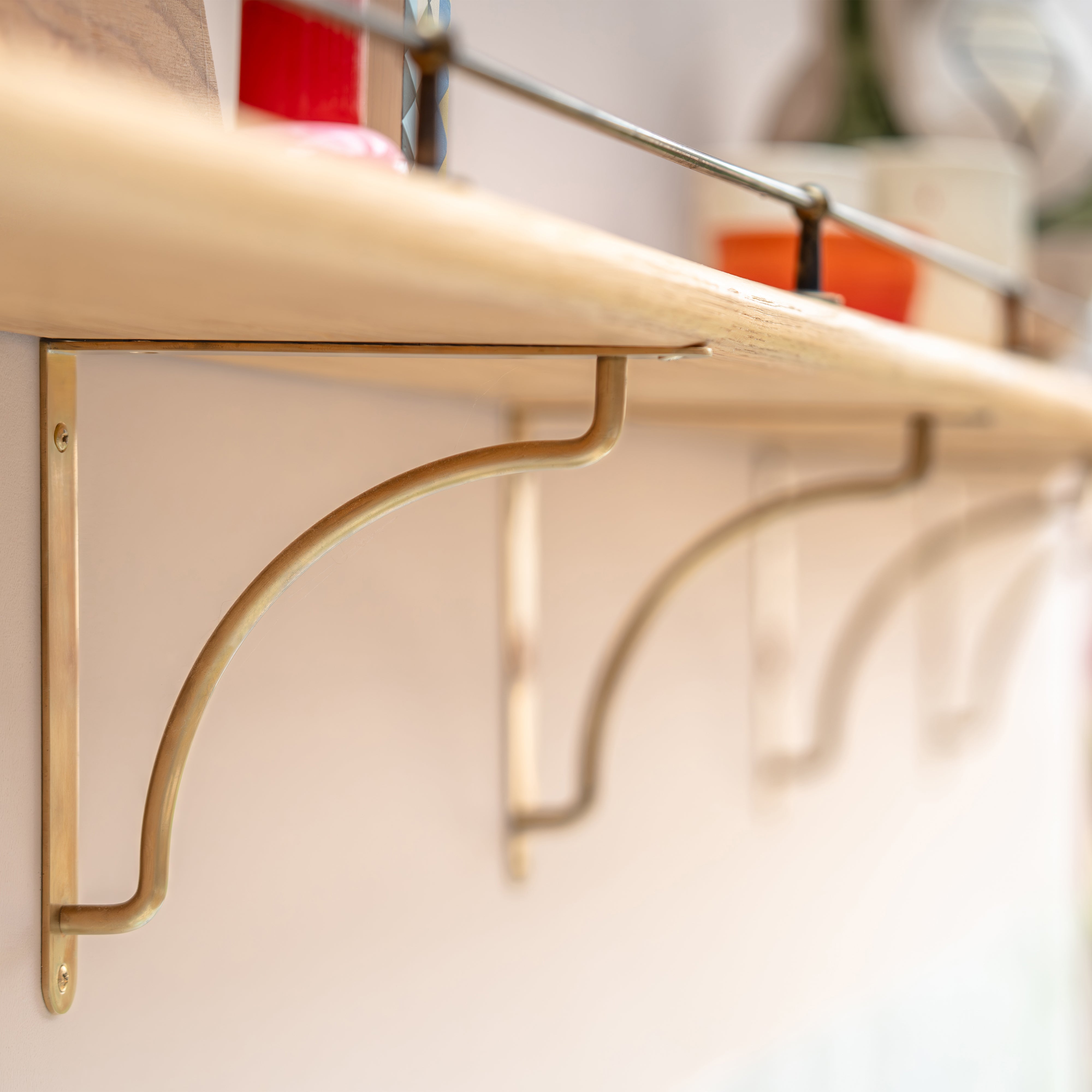 Kilburn Shelf Bracket 200mm in Antique Brass attached to a wooden shelf.