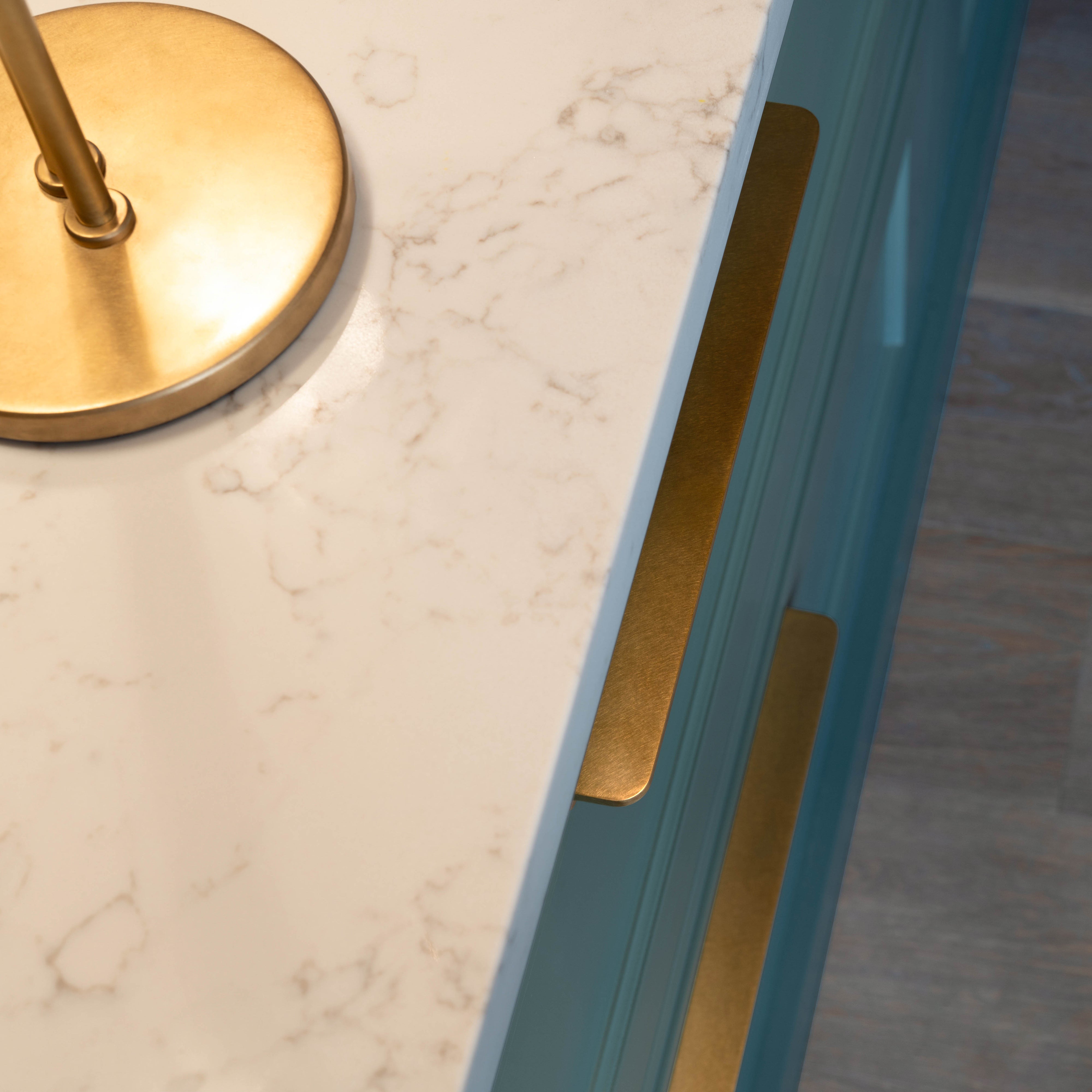 Close-up of teal cabinetry featuring the Oxford Furniture Handle Medium in Antique Brass.