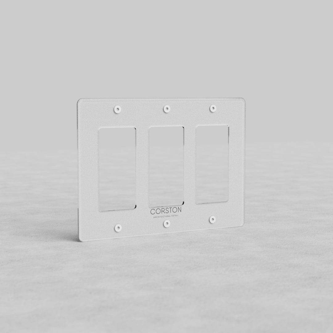 Clear 3-gang outlet plate, Kew US style, with beveled edges by Corston, displayed on a gray background.