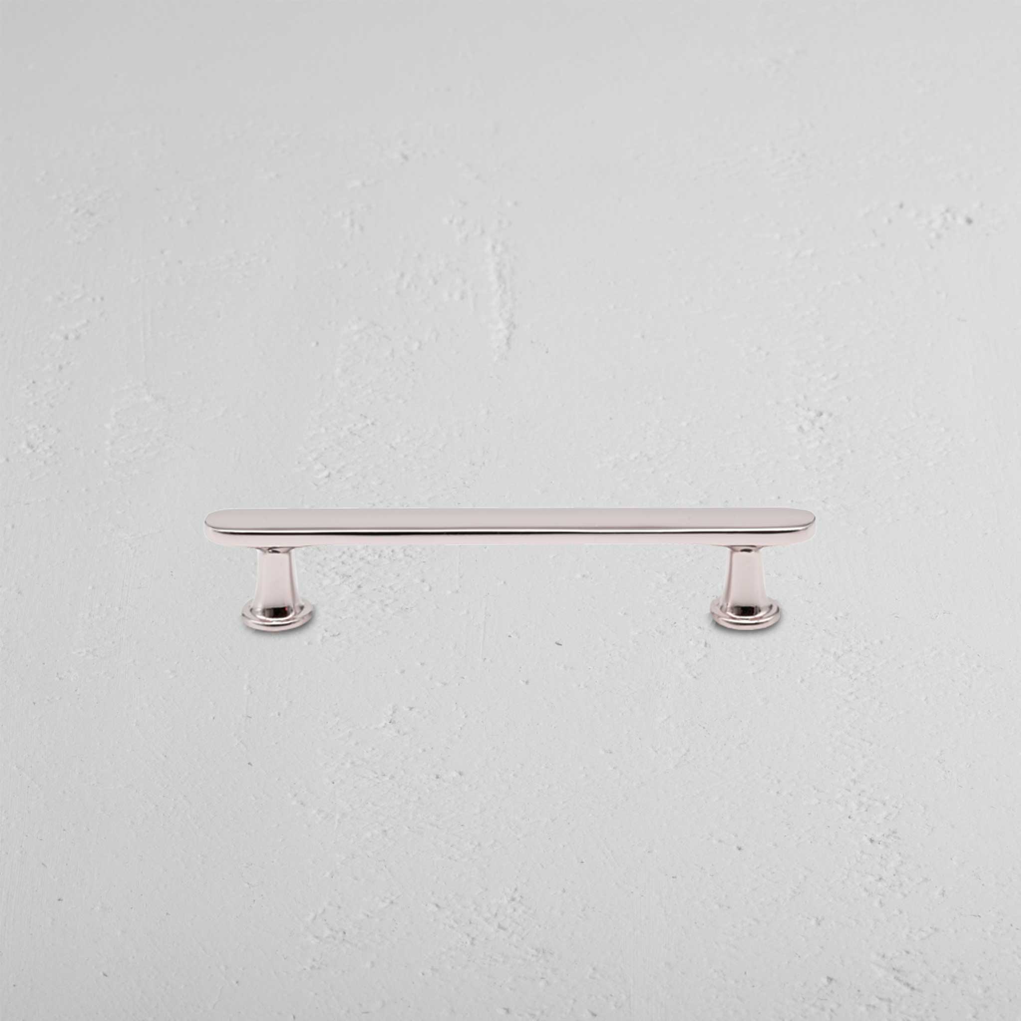 Milliner Furniture Handle Small in polished nickel finish with rounded ends, mounted on a white surface.
