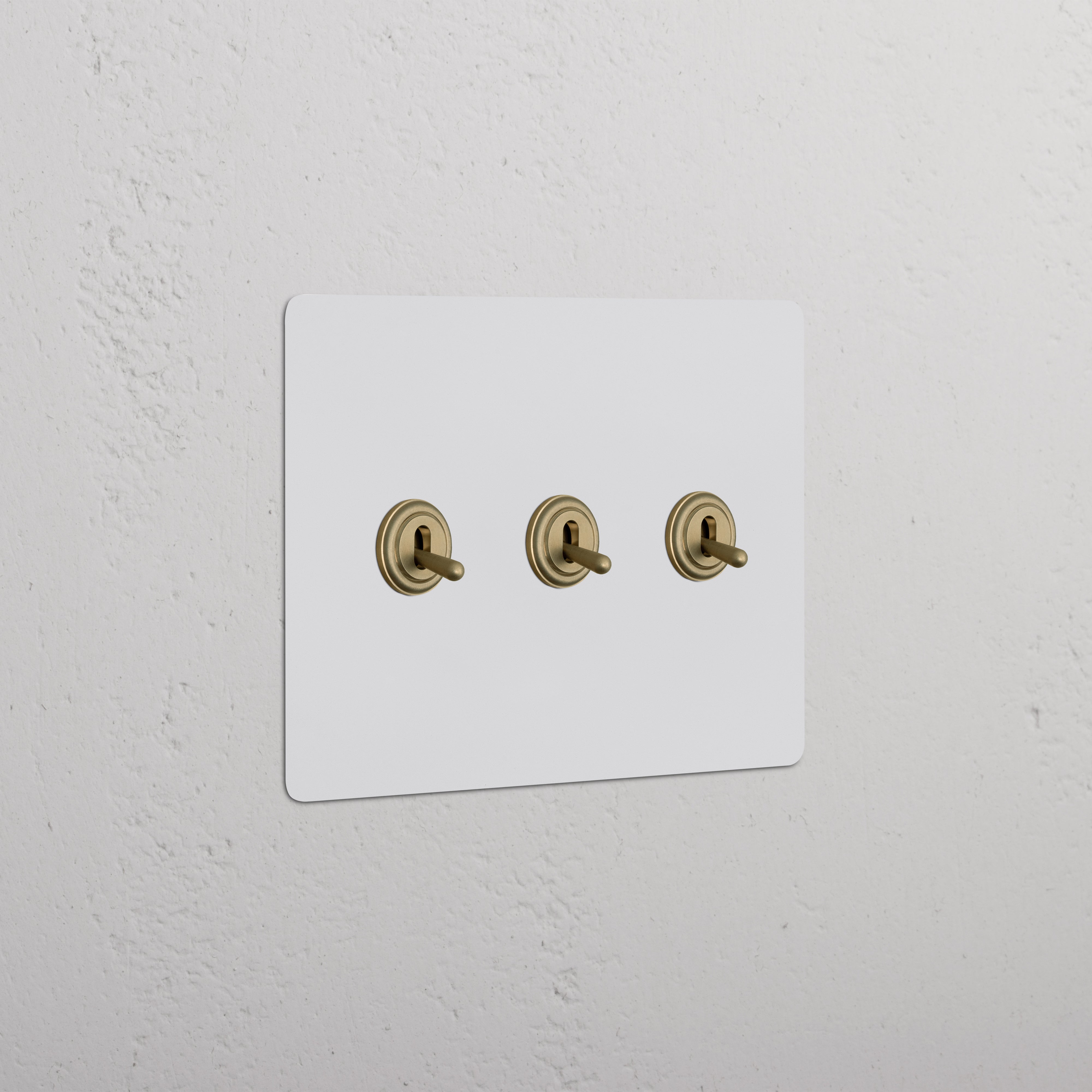 Kew 3G Toggle Switch - Paintable Antique Brass with three horizontally aligned toggles on a rectangular plate.