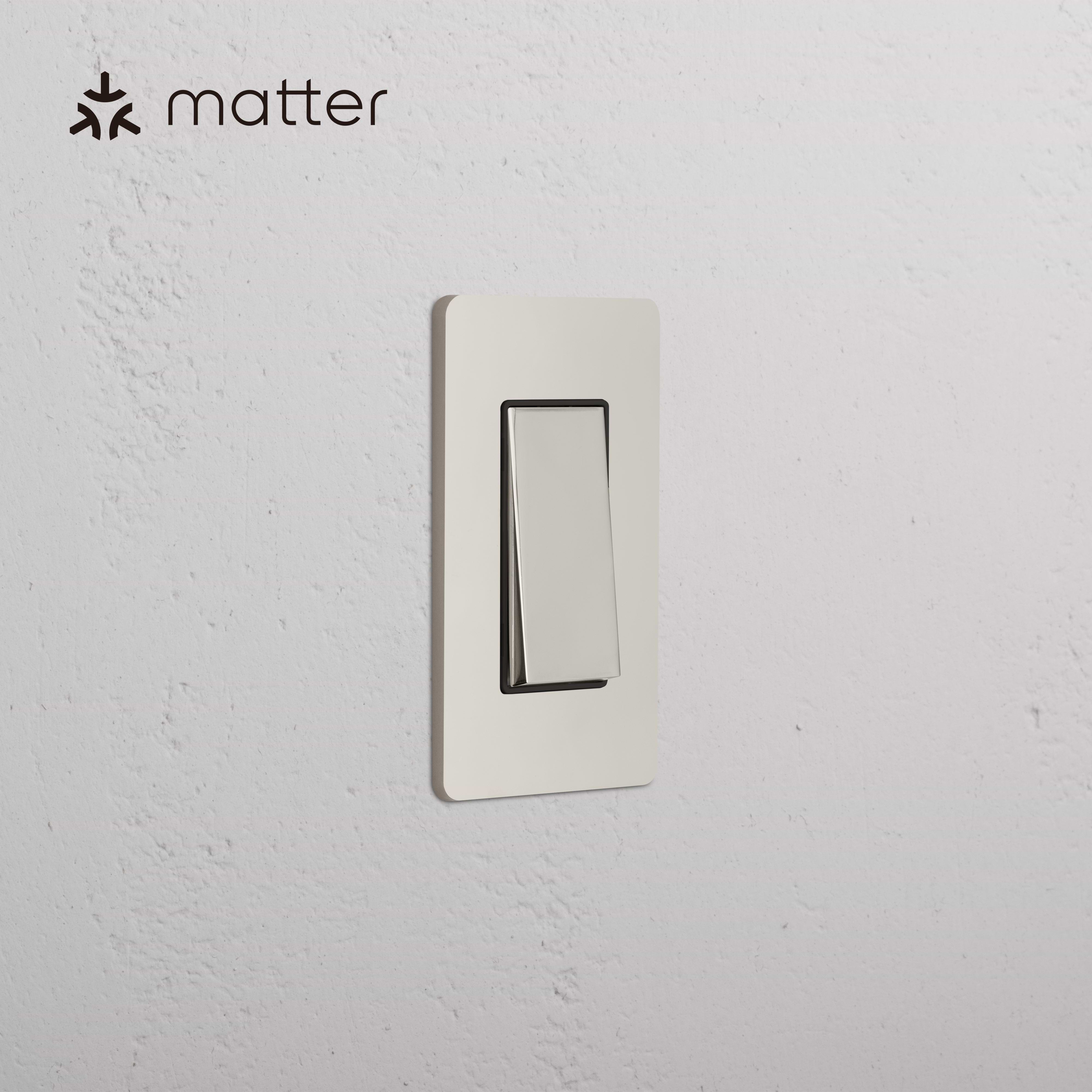 Grove 1G Smart Retractive Rocker Switch in Polished Nickel Black, mounted on a white textured wall.