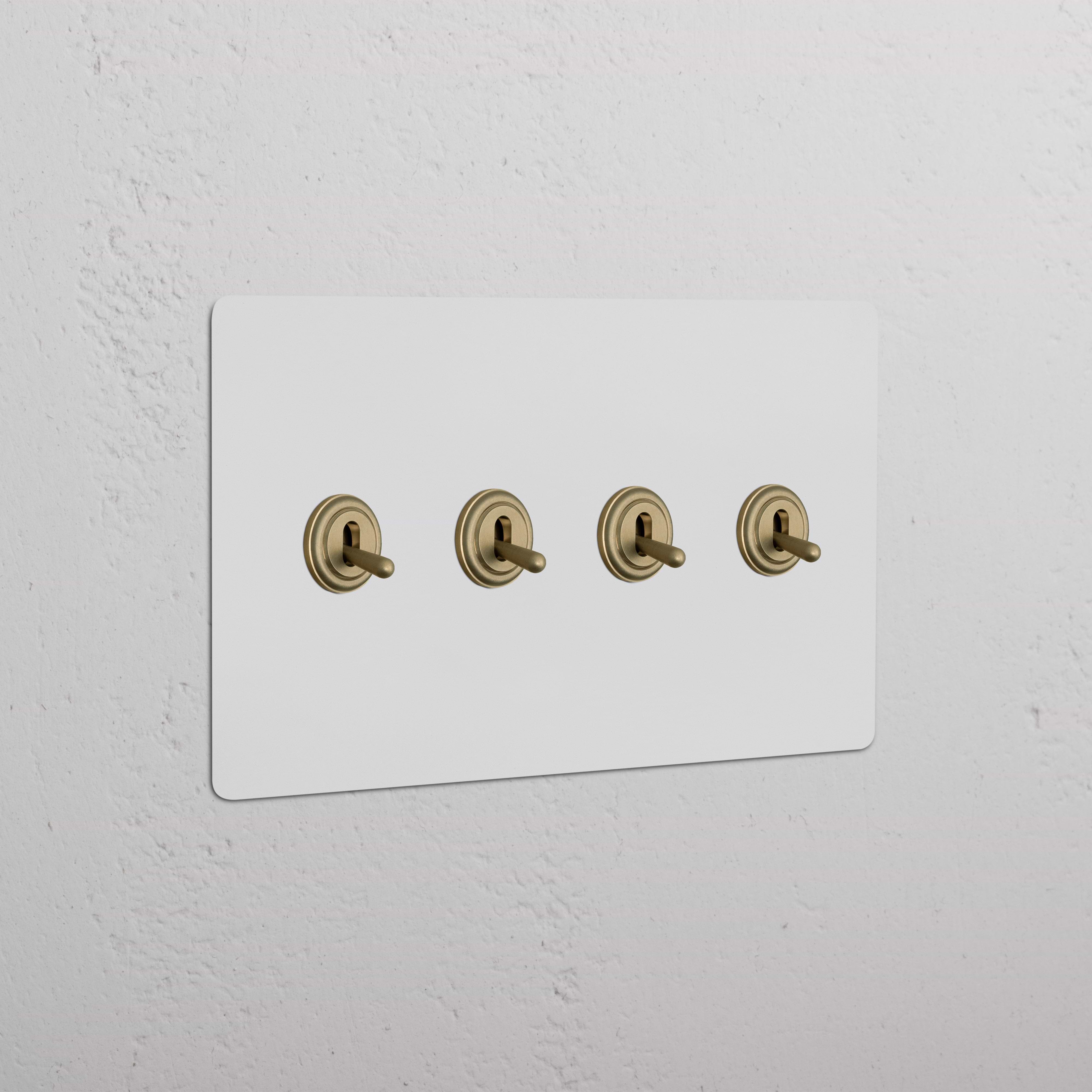 Kew 4G Toggle Switch with four paintable antique brass toggles on a white wall plate, shown installed.