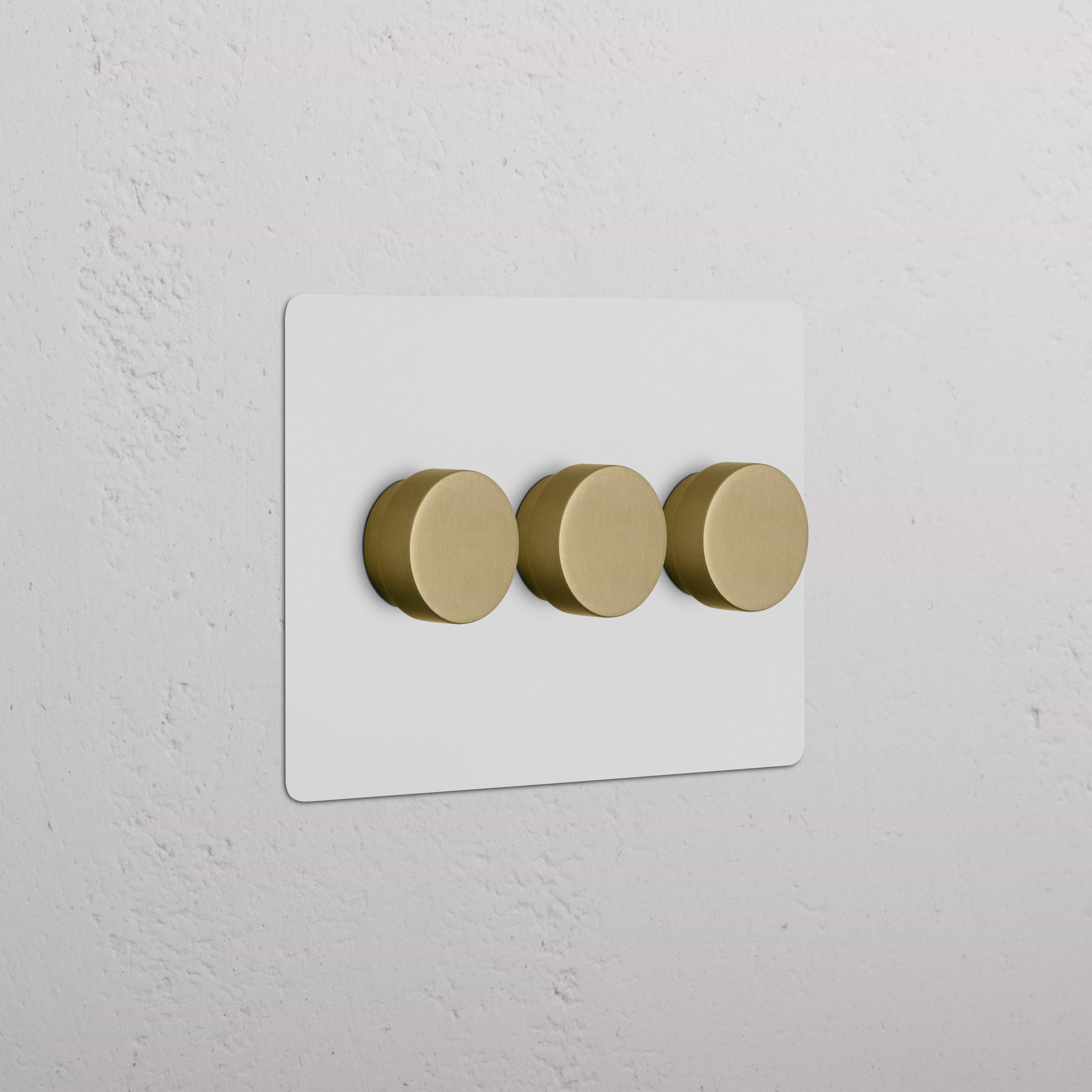 Kew 3G Dimmer Switch in paintable antique brass finish with three round knobs on a white plate.
