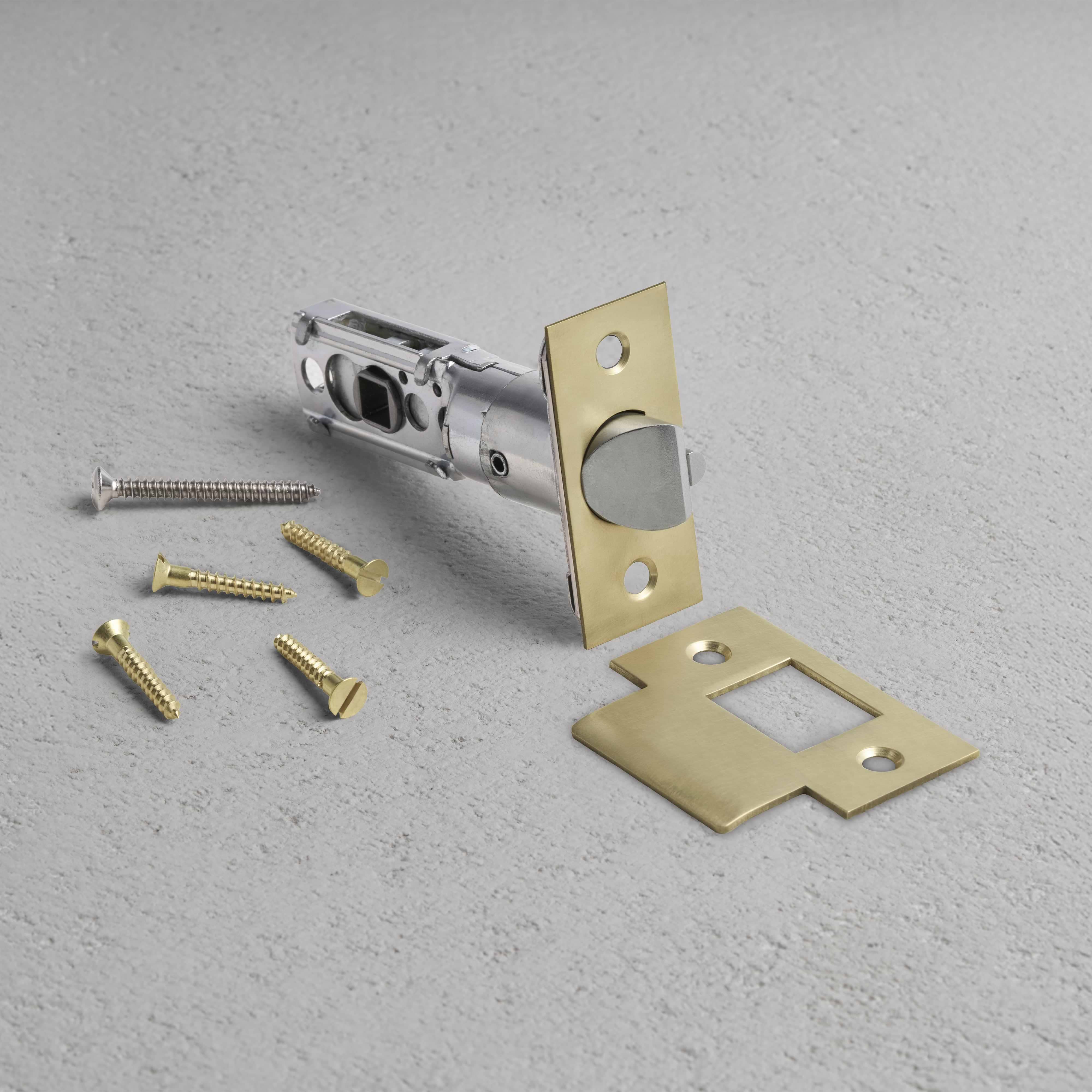 Passage Tubular Latch in Antique Brass finish, shown with matching faceplate, strike plate, and screws.