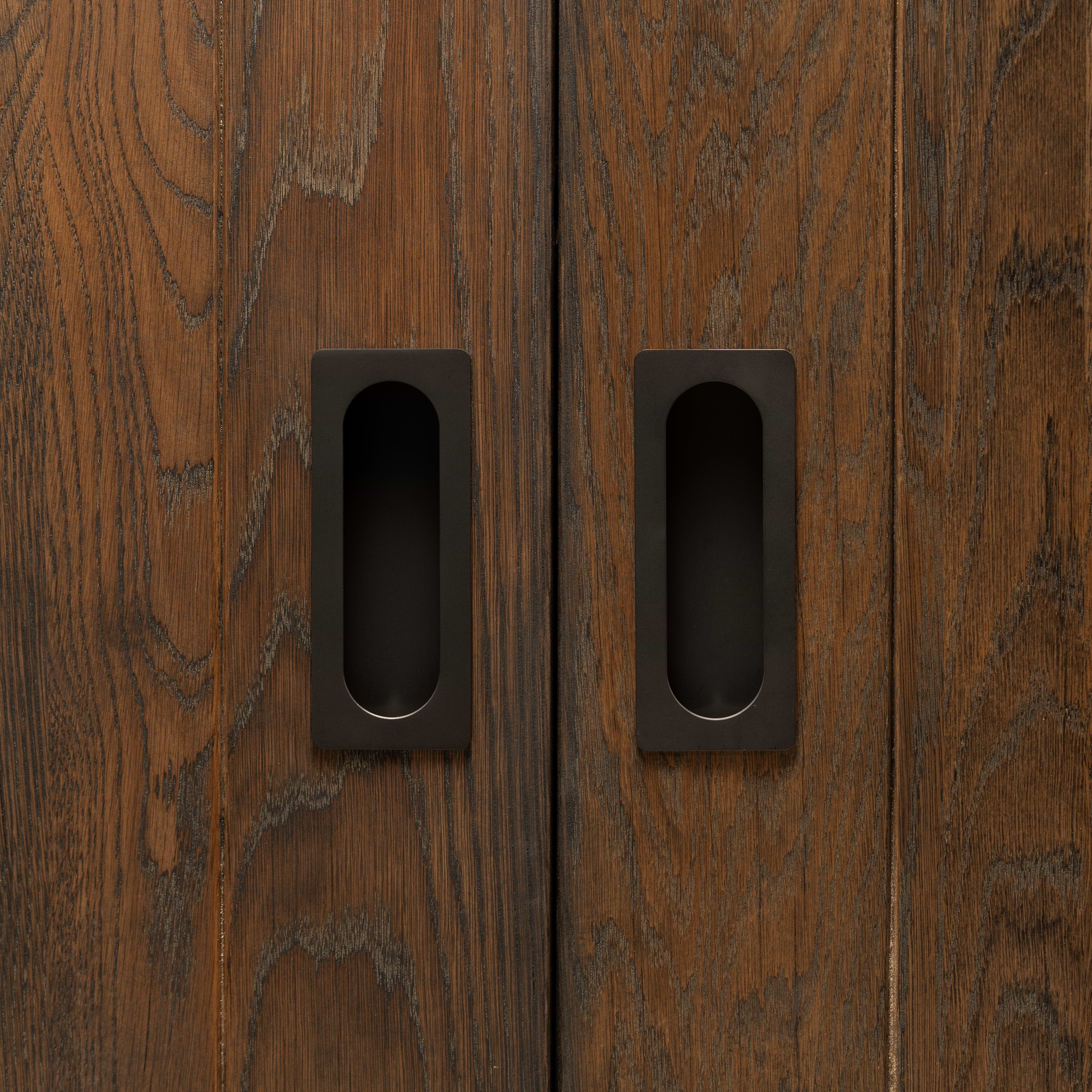 Regent Recessed Medium Pull in bronze installed on wooden cabinet doors, showing handle design and finish.