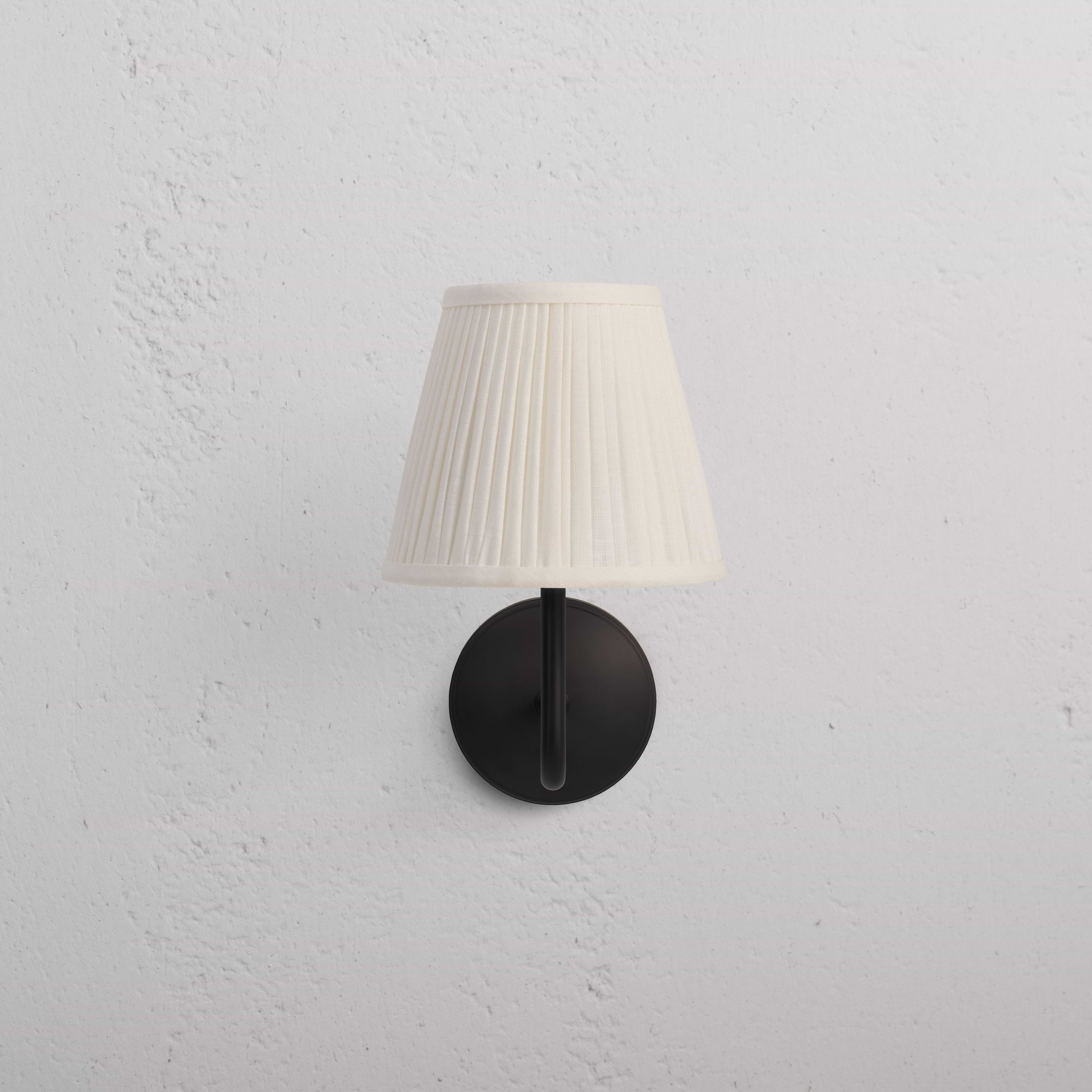 Malvern Medium Wall Light Alabaster White in bronze finish with pleated white shade mounted on wall.