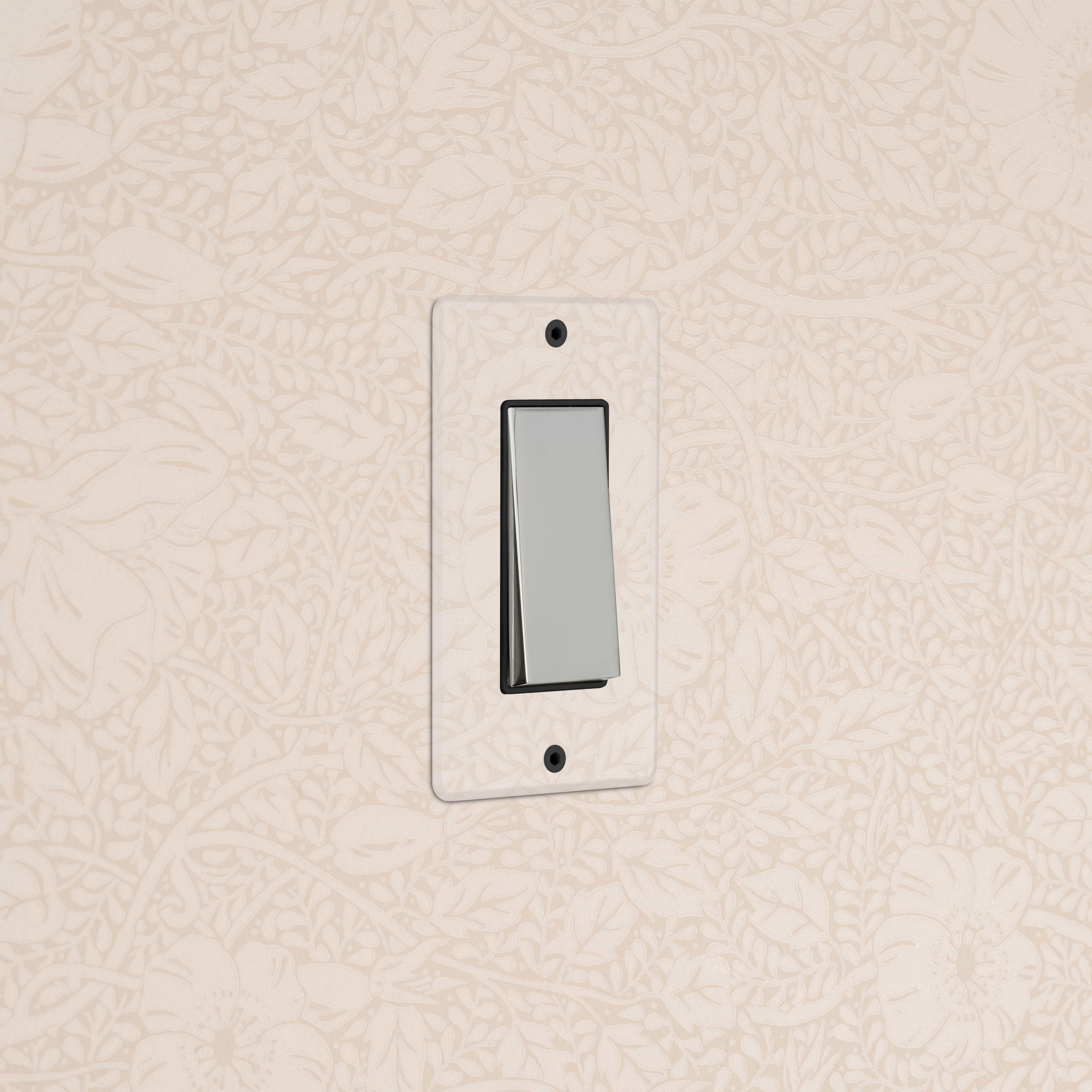 Kew 1G Double Pole Rocker Switch in clear polished nickel black, shown mounted on a wall.