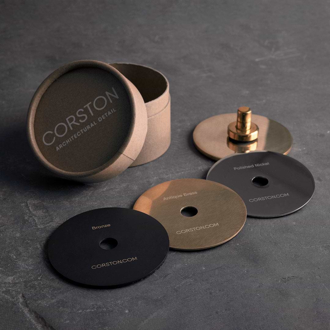 Sample Finish Set box with lid off, showing four labeled metal finish discs and a matching fixture piece.