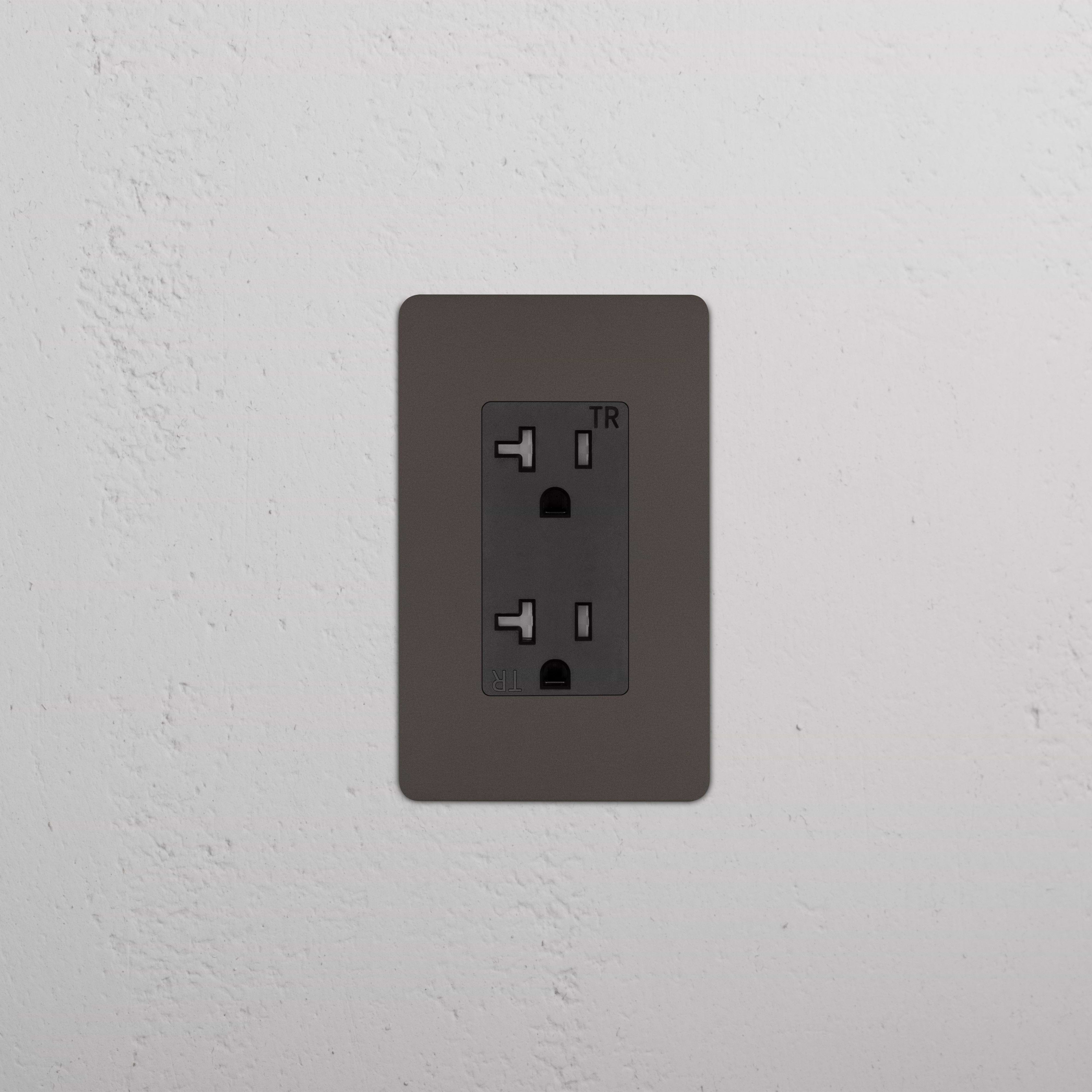 Kew 1G 20A Outlet in bronze black finish with single socket, mounted on a white textured wall.