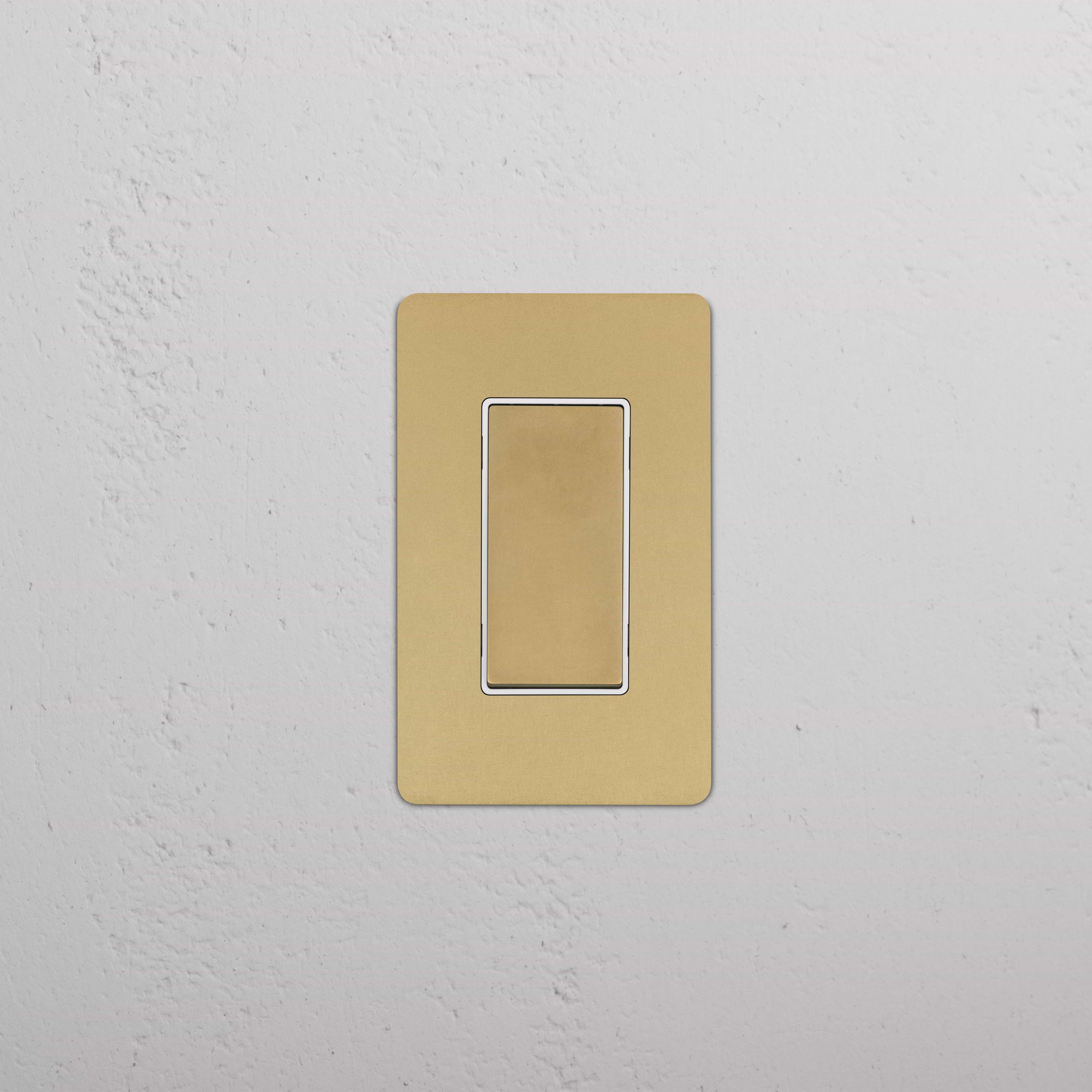 Kew 1G Dimming Retractive Rocker Switch in antique brass and white, mounted on a white textured wall.