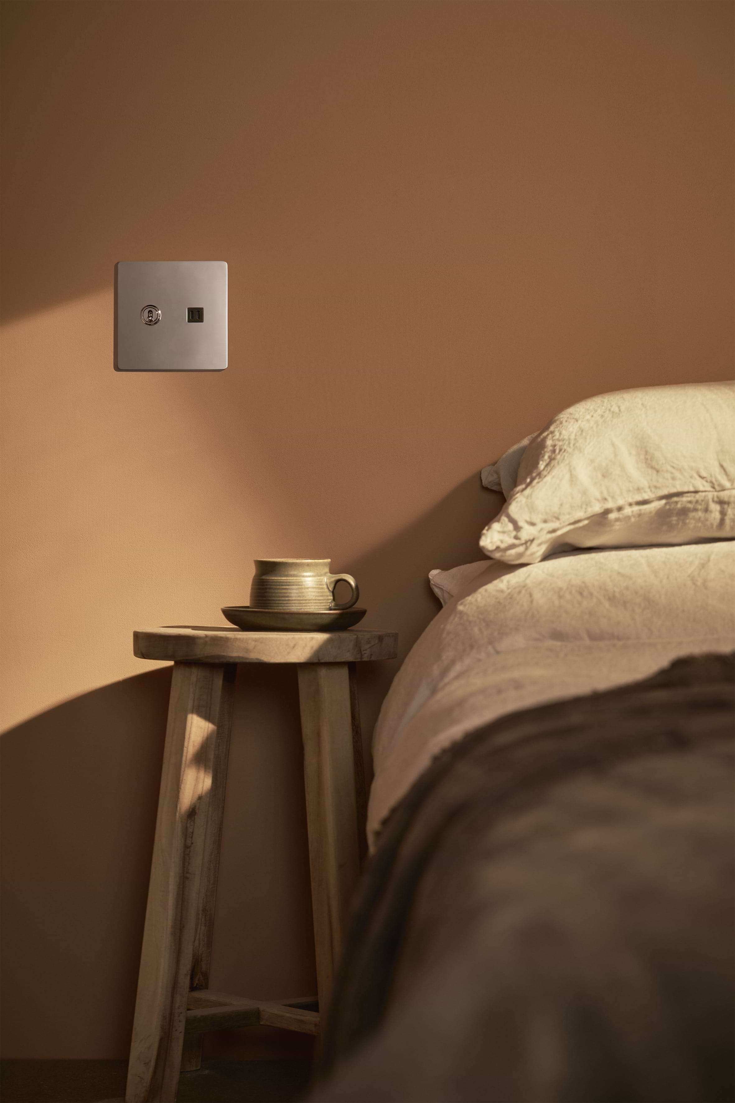Kew 2G Toggle Switch & Fast Charge USB in polished nickel black, mounted on a beige wall.