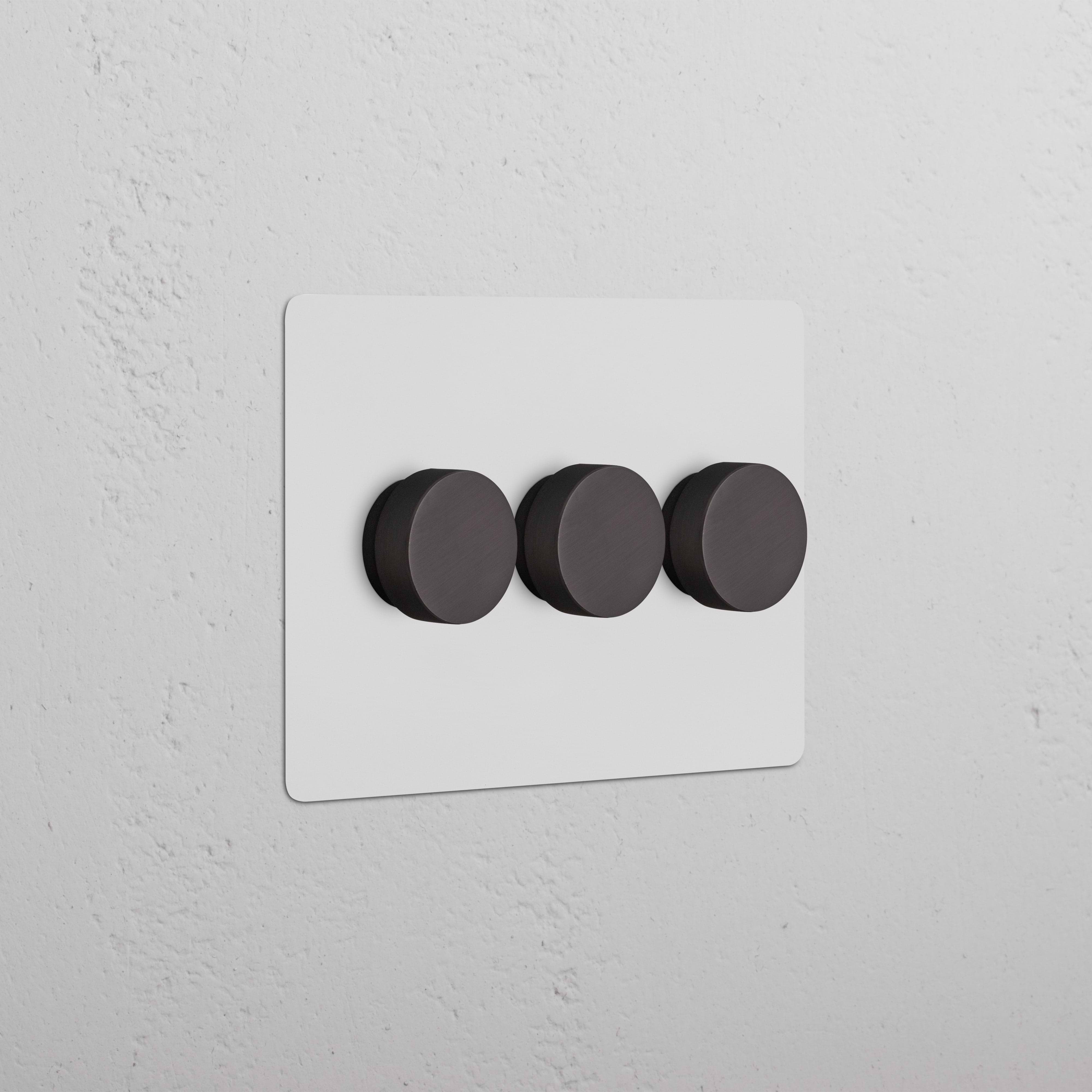 Kew 3G Dimmer Switch in a paintable bronze finish with three round black knobs on a rectangular plate.