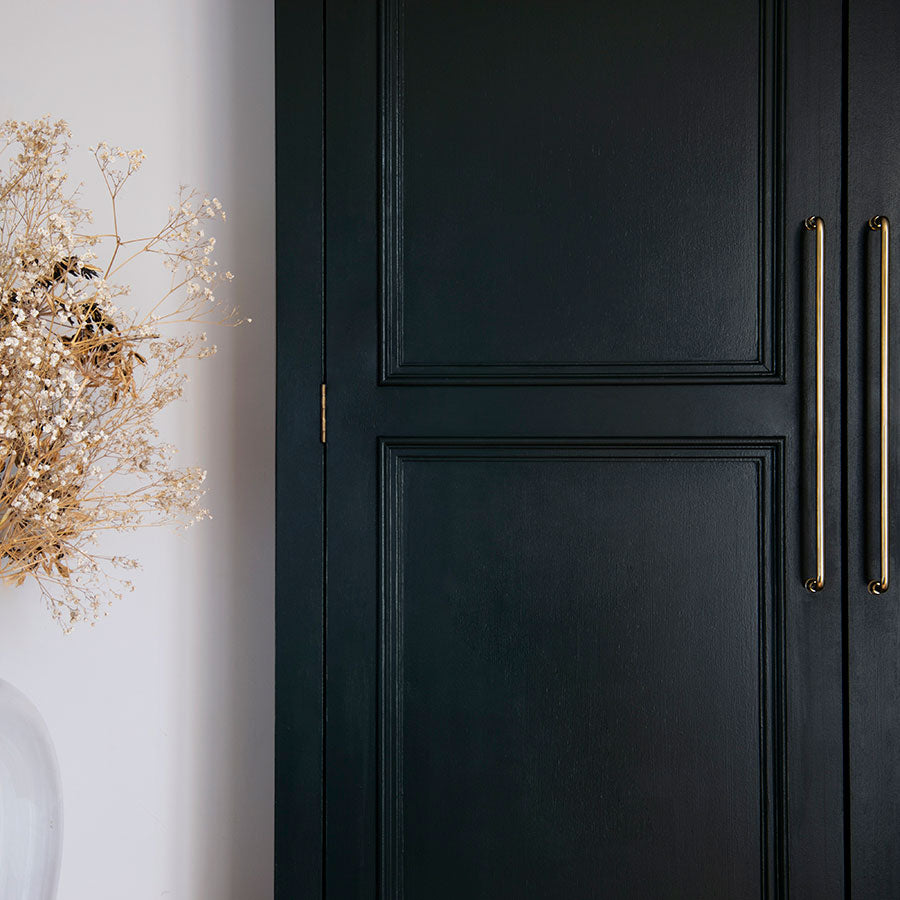 Sycamore Furniture Handle Large in antique brass fitted to a dark green cabinet drawer.