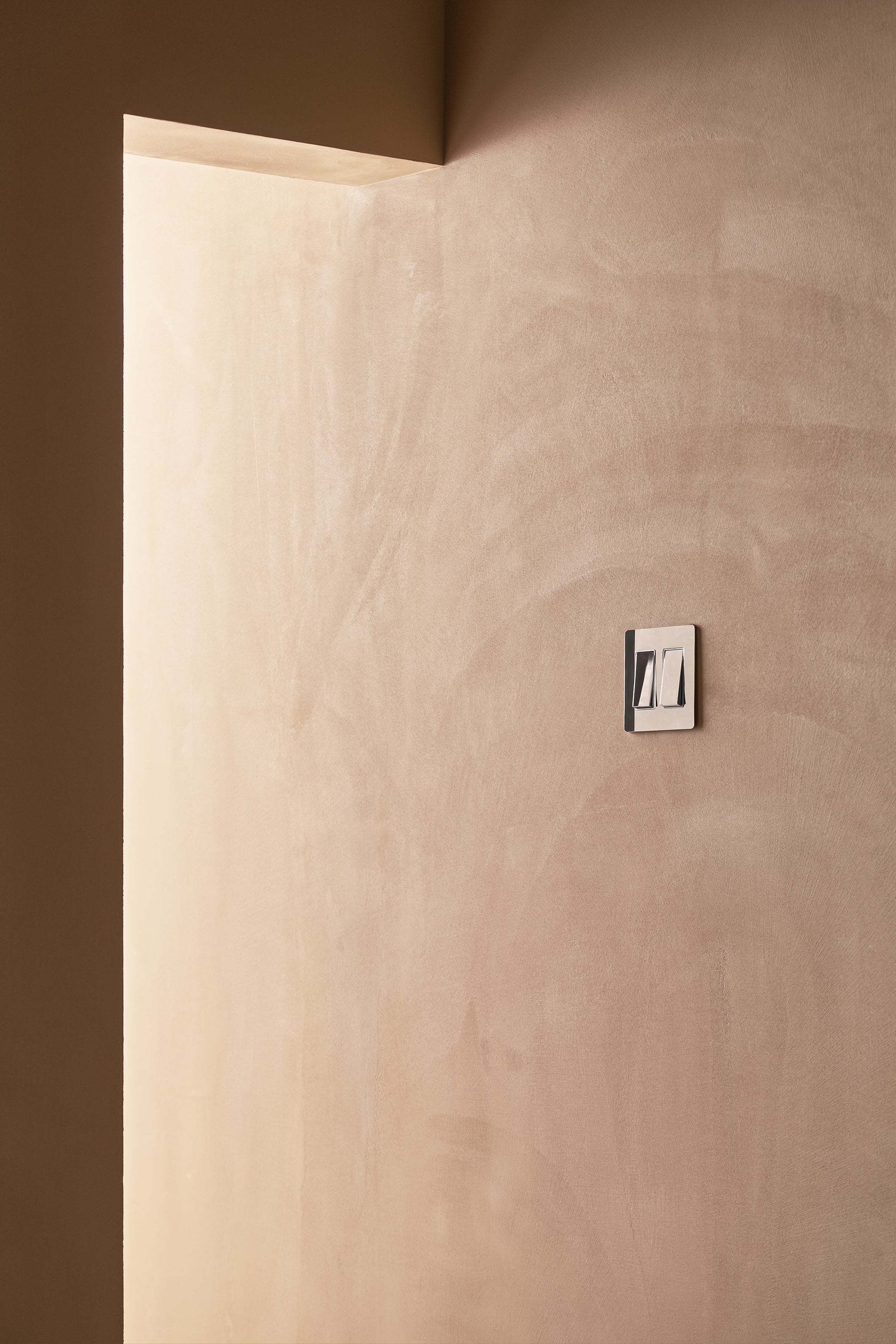 Kew 2G Rocker Switch in Polished Nickel White mounted on a wall, showing two white rocker switches.