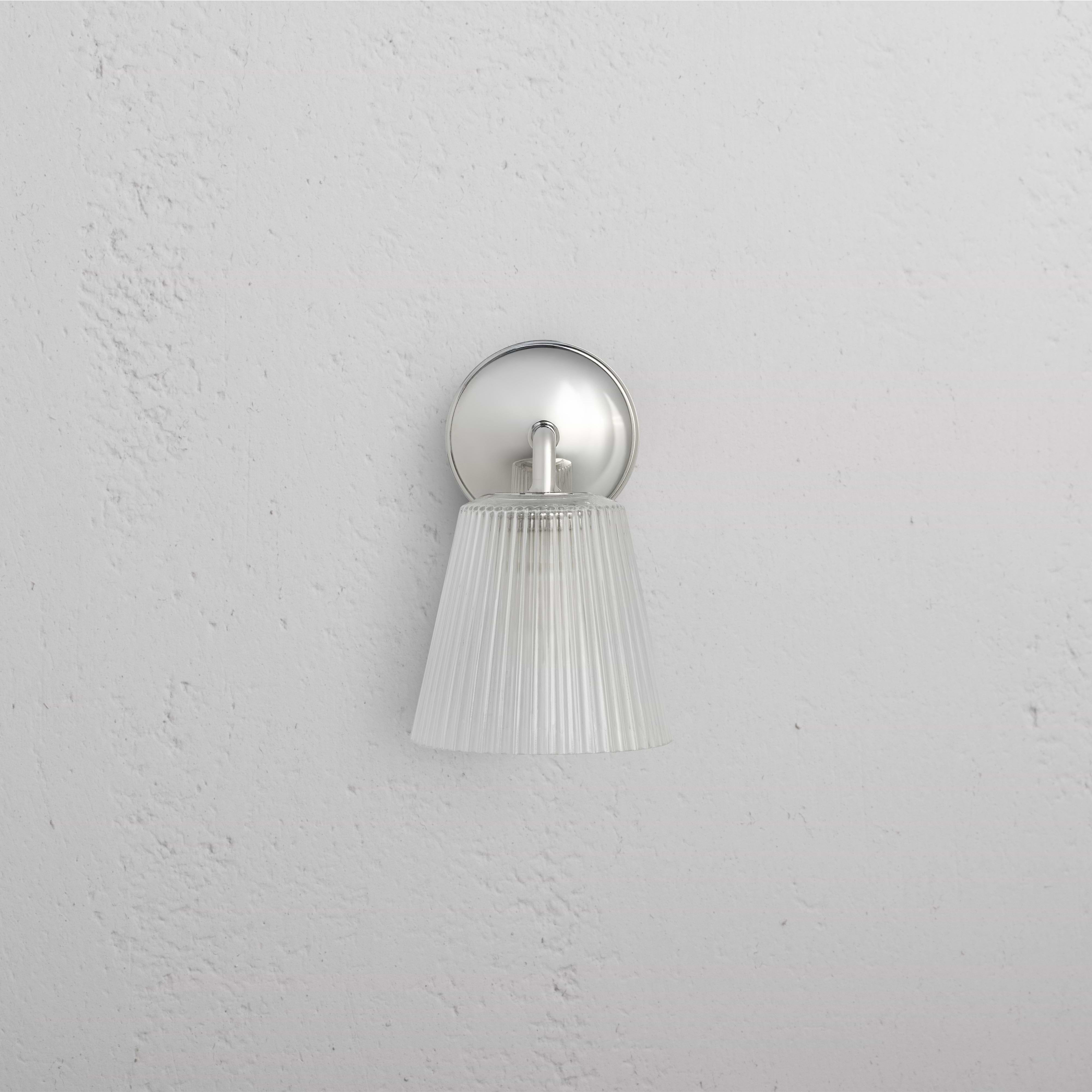 Richmond Medium Wall Light with fluted clear glass shade and polished nickel base mounted on a white wall.