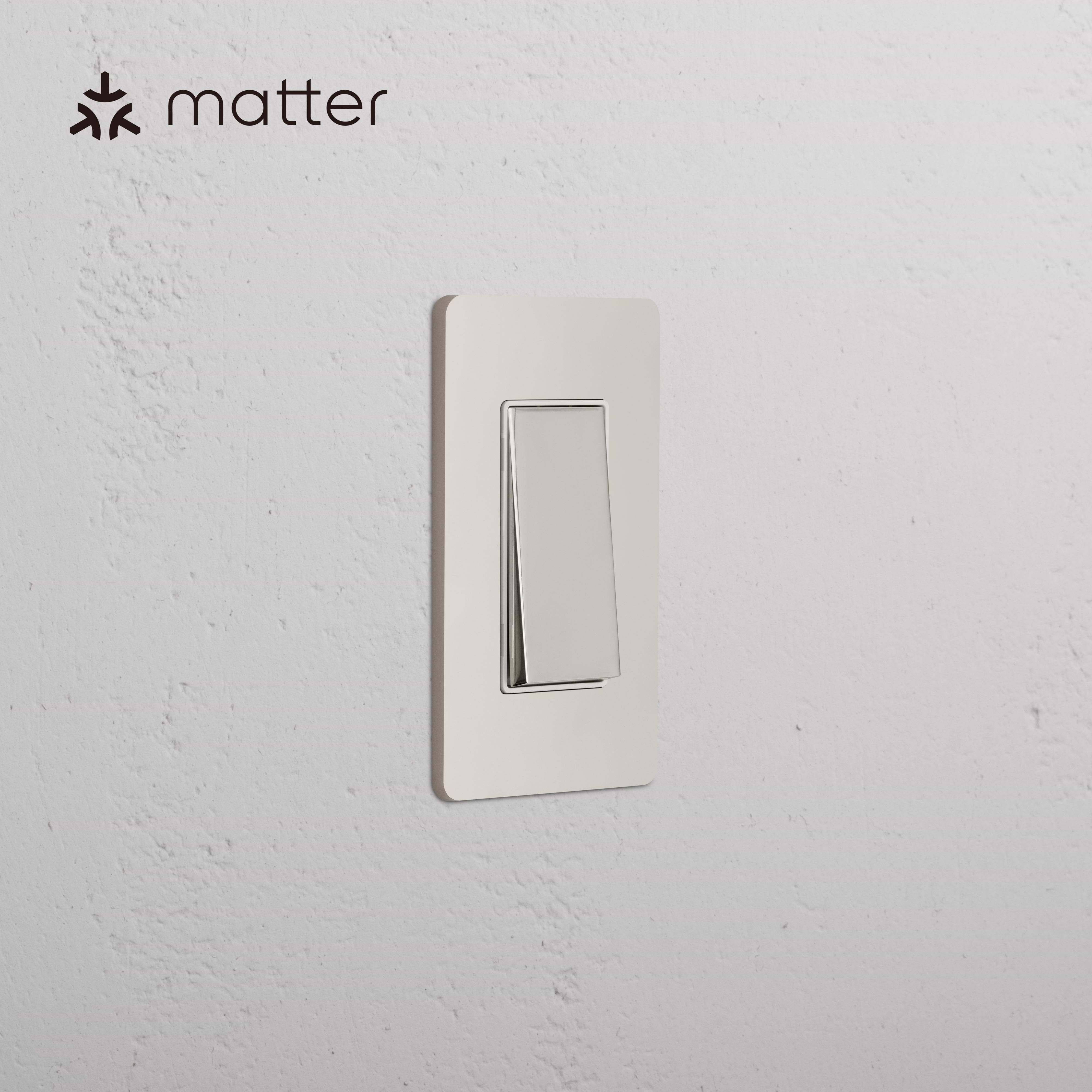 Grove 1G Smart Retractive Rocker Switch in Polished Nickel White, mounted on a white textured wall.