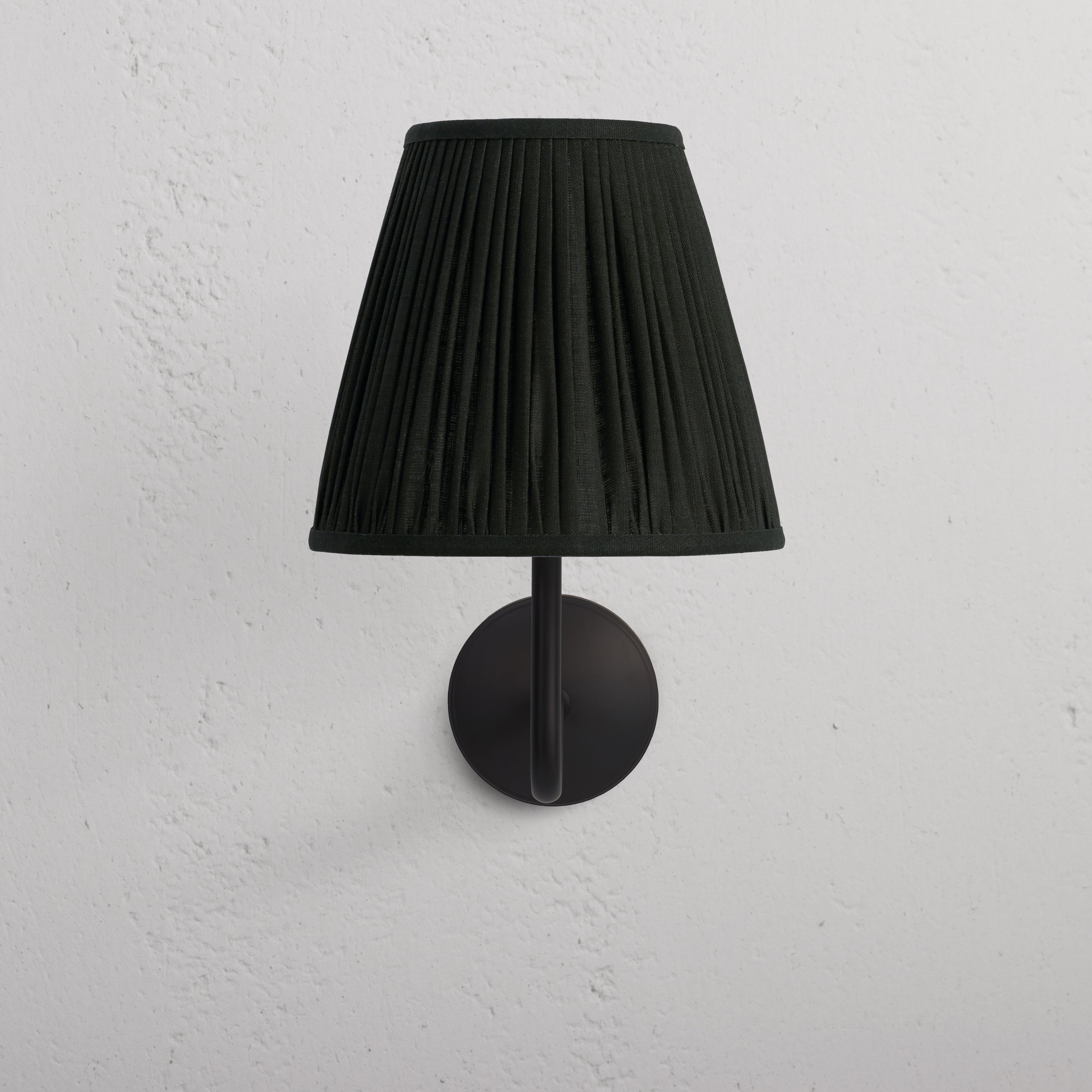 Large Malvern Wall Light in deep green with bronze mount, wall-mounted against a white textured surface.