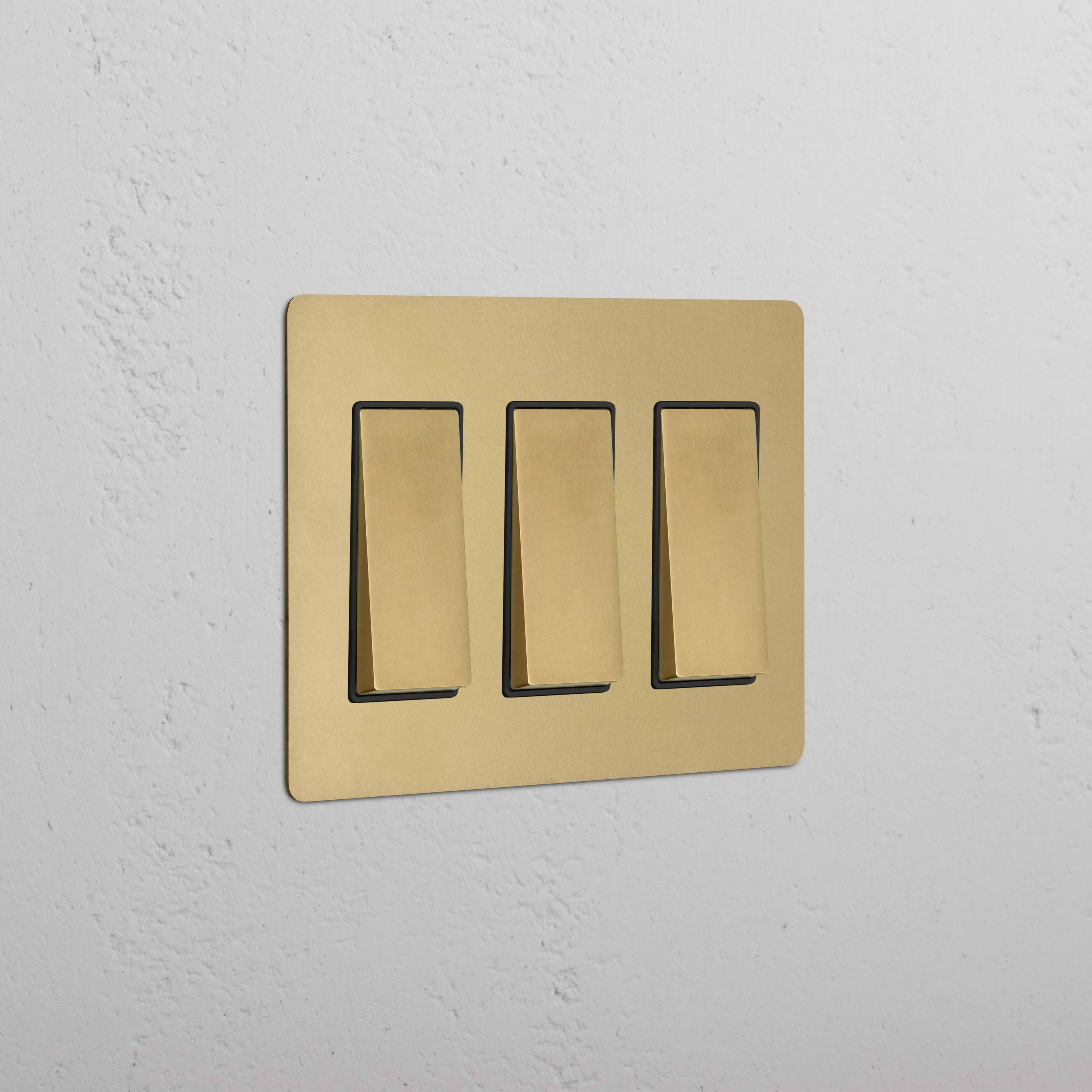 Kew 3G Rocker Switch in Antique Brass Black finish, shown mounted on a wall.