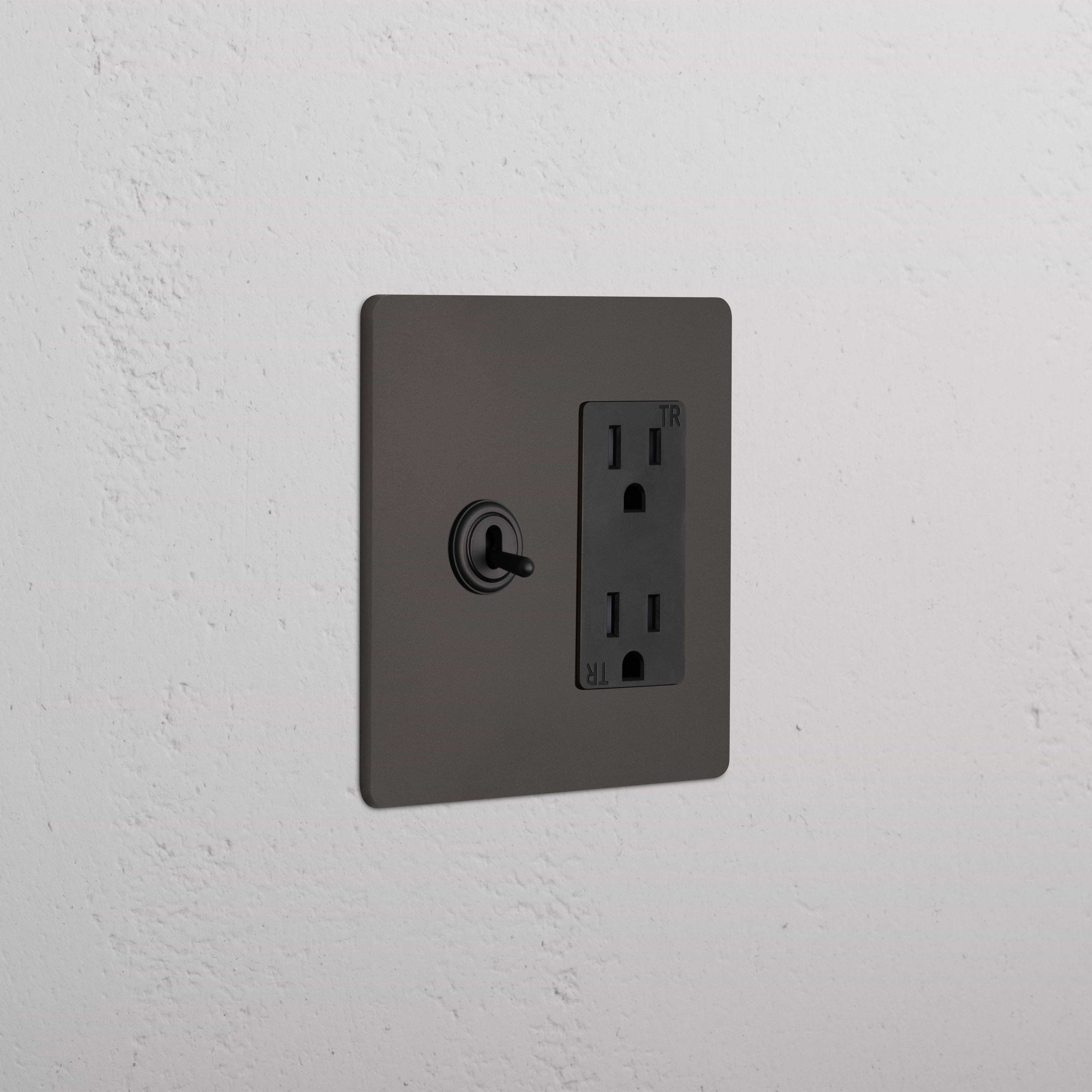 Grove 2G Toggle Switch & Outlet in bronze black with left toggle switch and right double power outlet.